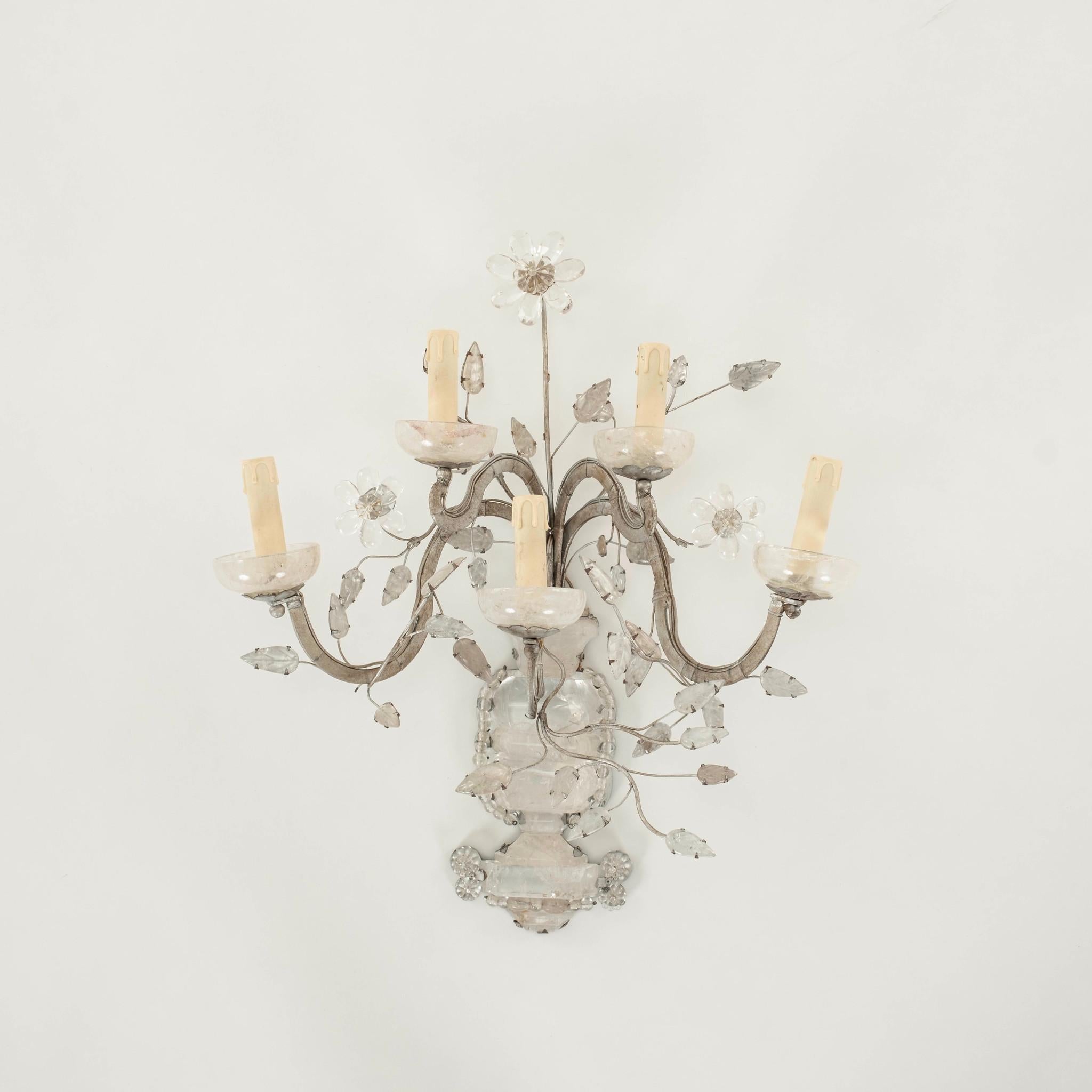 A 20th Century pair of Maison Baguès style five arm,  silver gilt candelabra shaped sconces featuring massive rock crystal bases and foliage adorned with crystal flowers.