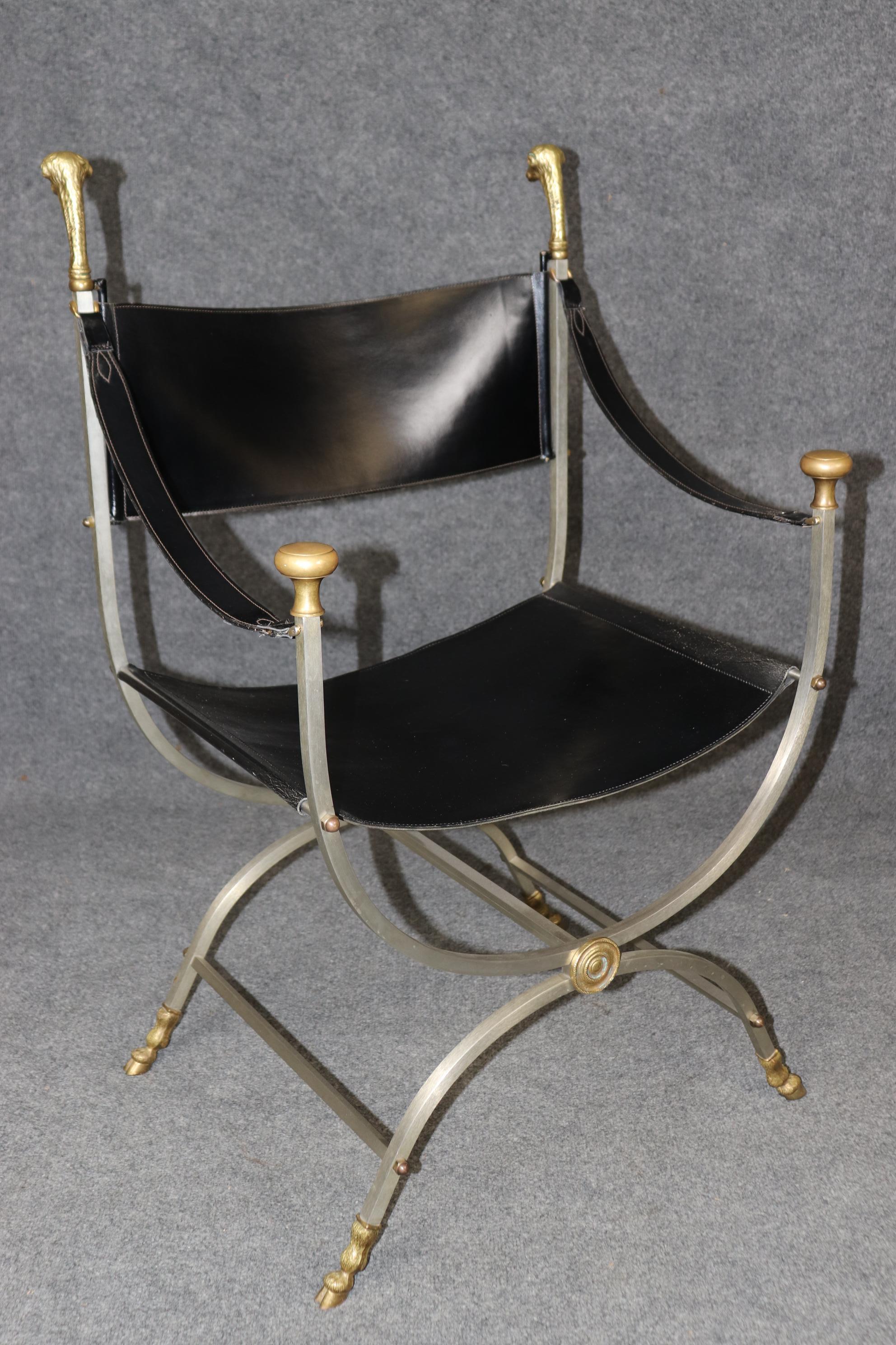 
This is a superb pair of Maison Jansen Attributed brass and steel ram's head savonarola stule or cerule style armchairs. They feature naturalistic cast rams heads of the highest quality and cloven hoof feet. The contrasting brass and steel work