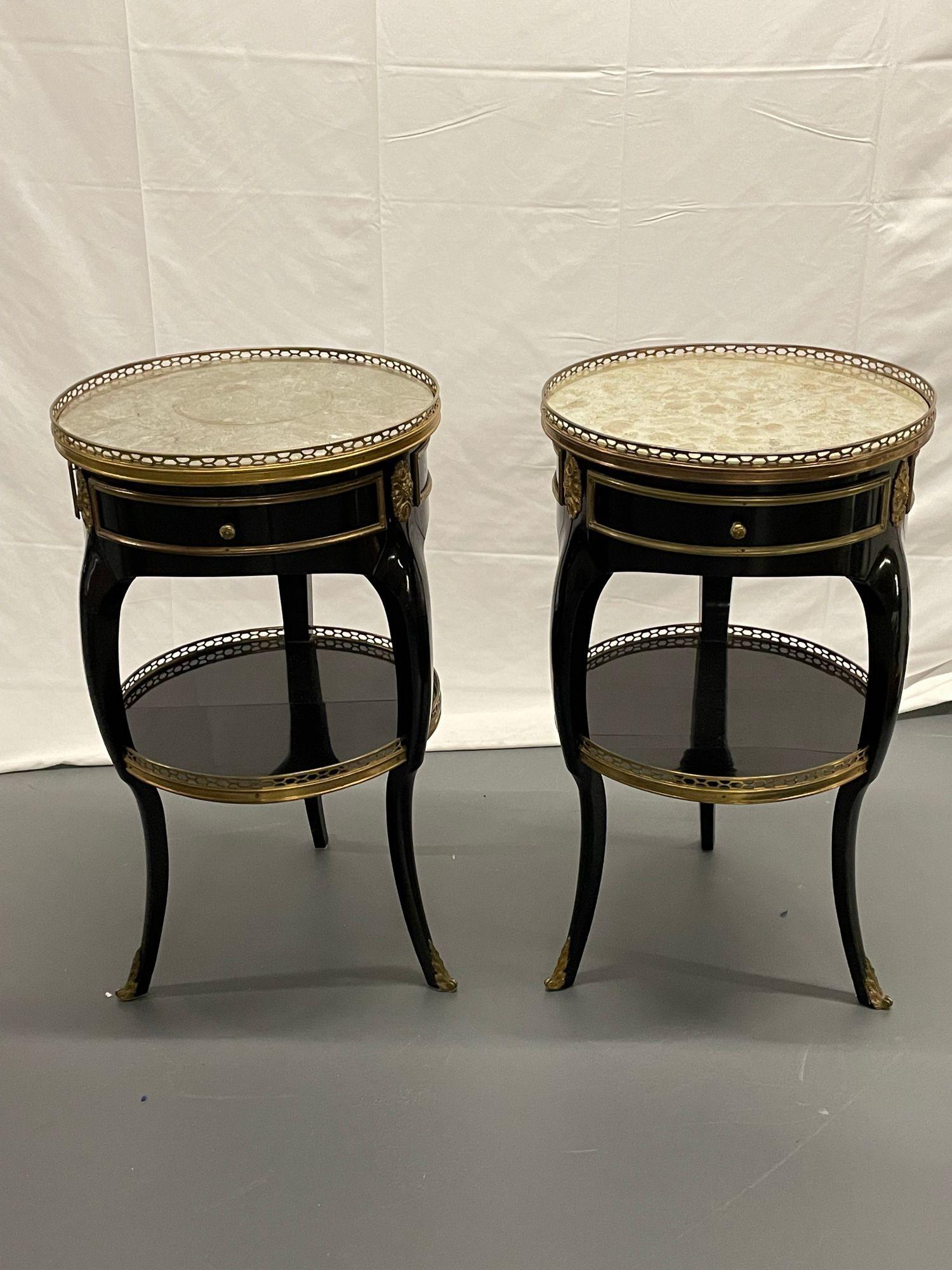 Pair of Maison Jansen Hollywood Regency style Gueridon, end / side tables, silver leaf glass tops. 
 
This stunning pair having silver gilt glass tops, mounted around pierced bronze galleried frames, supported by ebony bronze, mounted table bases