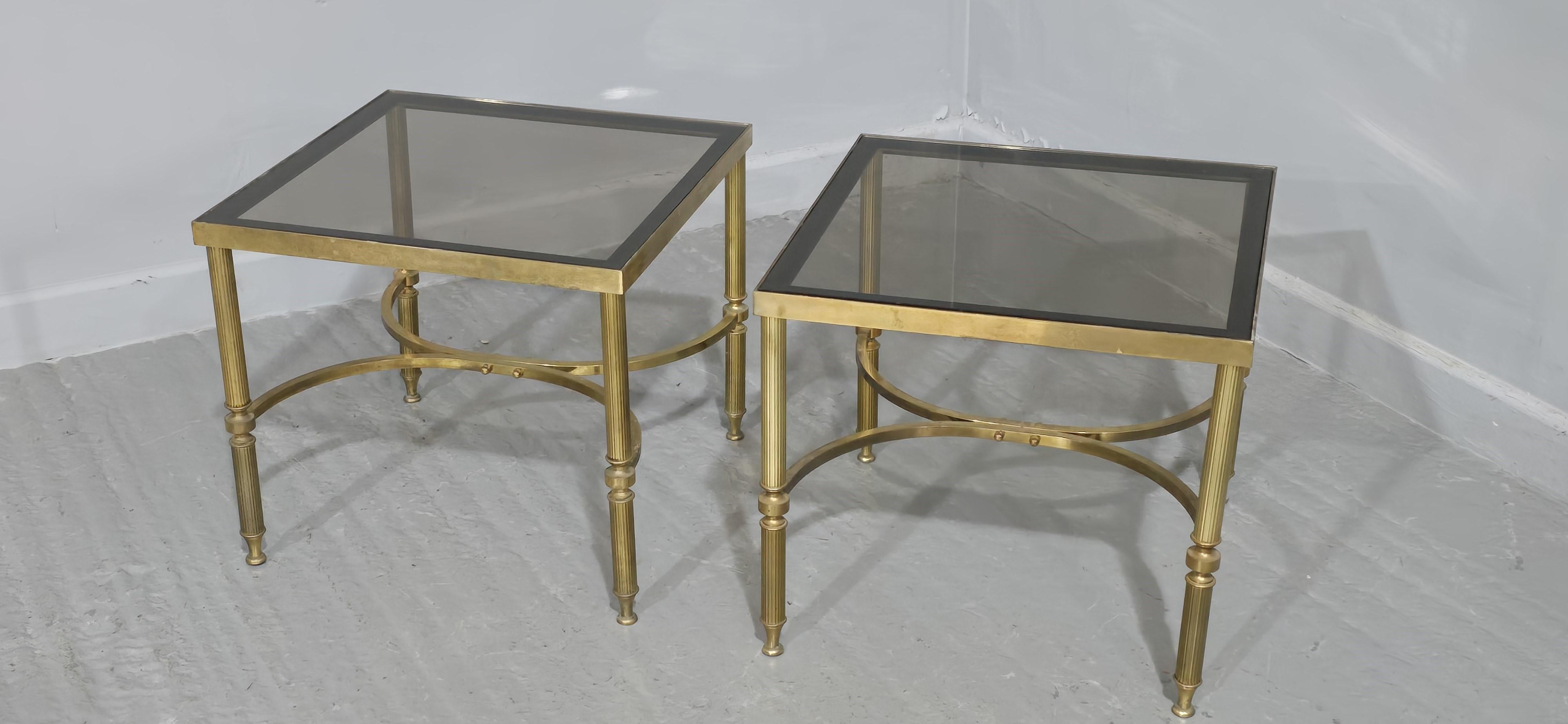 A very nice pair of brass Maison Jansen style lamp sde tables wiith smoked glass tops, reeded leds and U shaped understretcher, in overall very good condition.

16