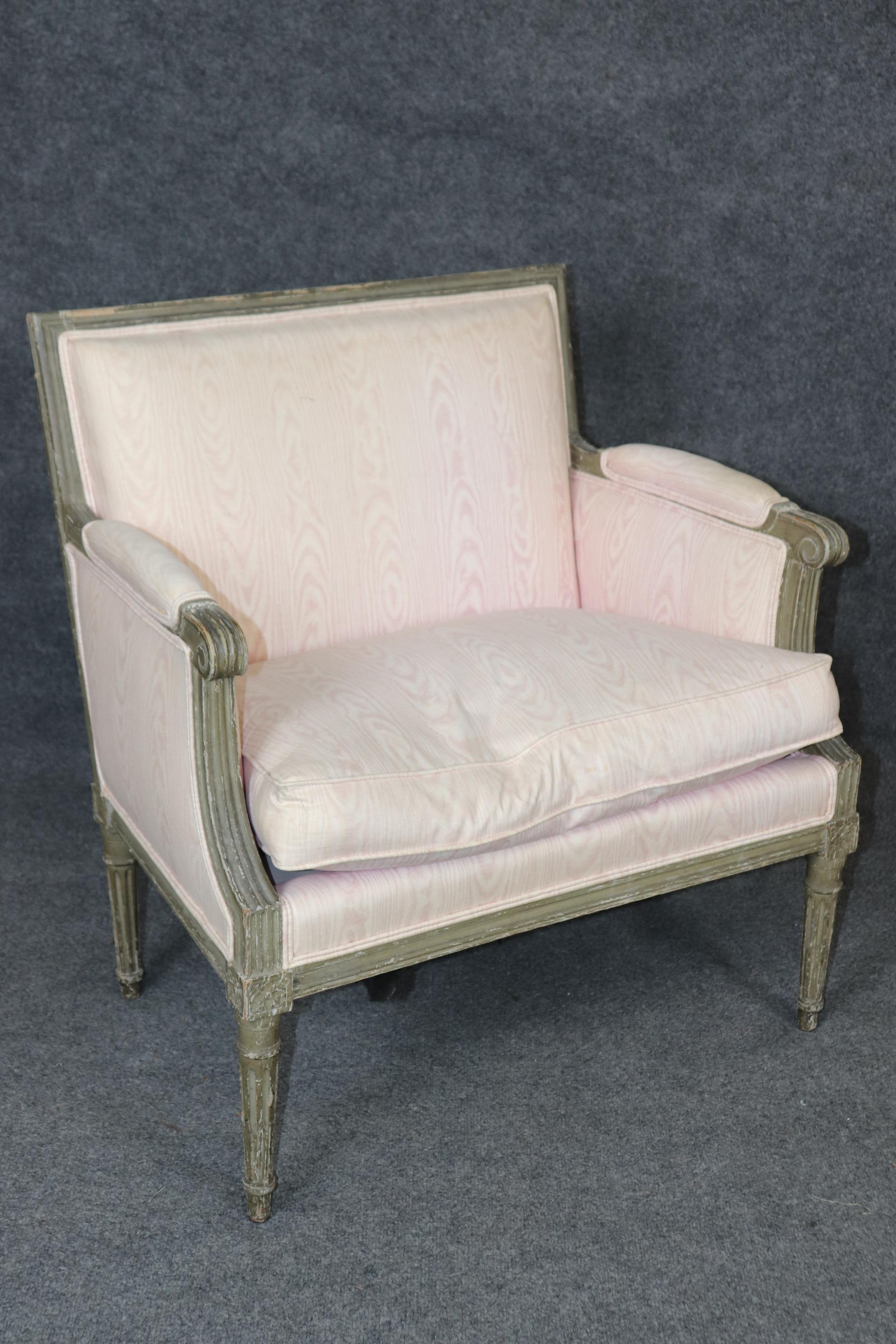This is a fantastic and very rare pair of Directoire or Louis XVI style Maison Jansen marquis or Bergere chairs. The chairs are in an original grayish green or greenish gray painted finish and show distressing from time and age. The chairs are in
