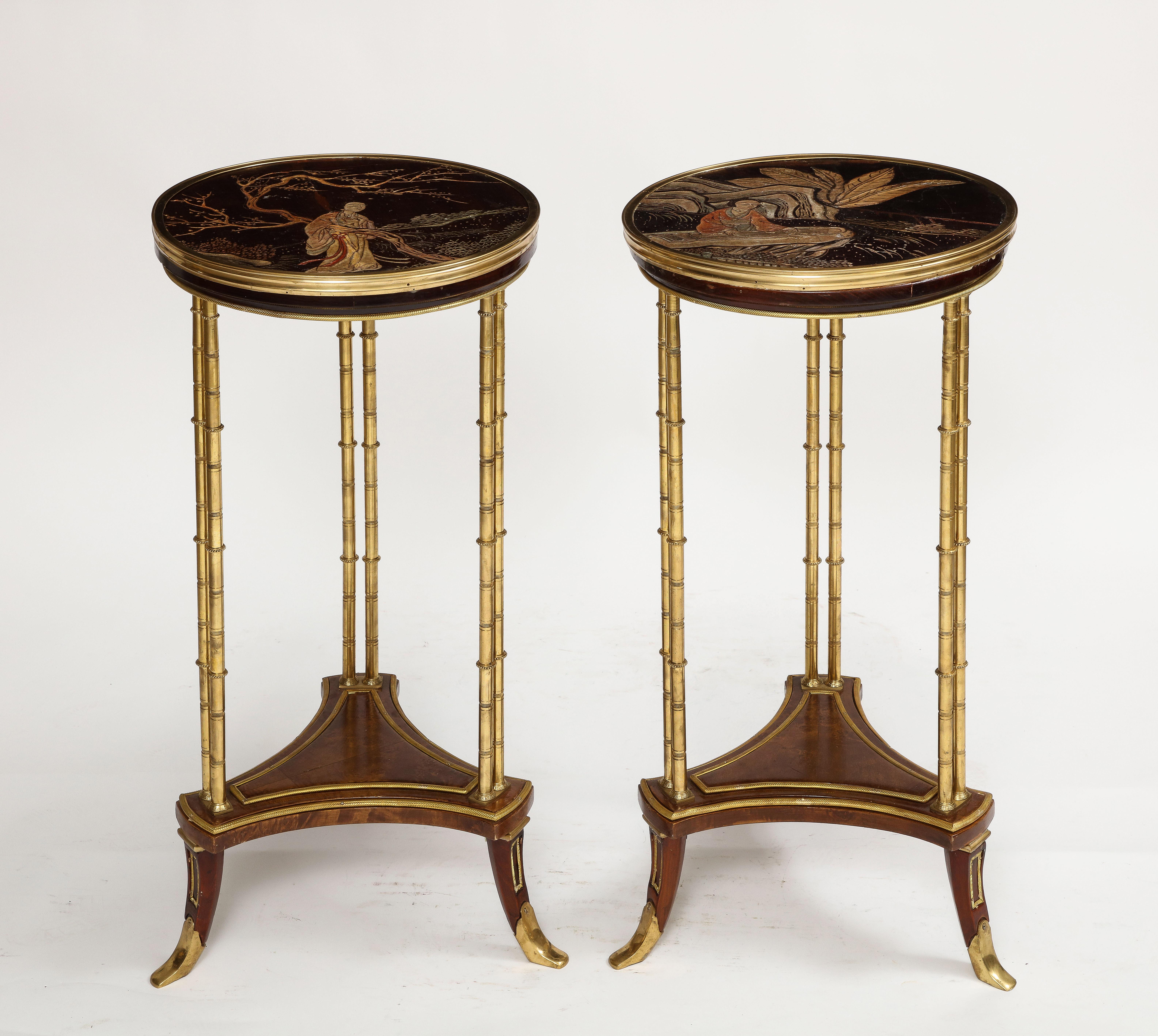 A Magnificent Pair of Maison Jansen Style French Chinoiserie Gueridon Side Tables in the manner of Adam Weisweiler. Each with Chinese lacquered Coromandel tops emblematic of Chinese figures. The legs are Gilt Bronze ormolu and wonderfully designed