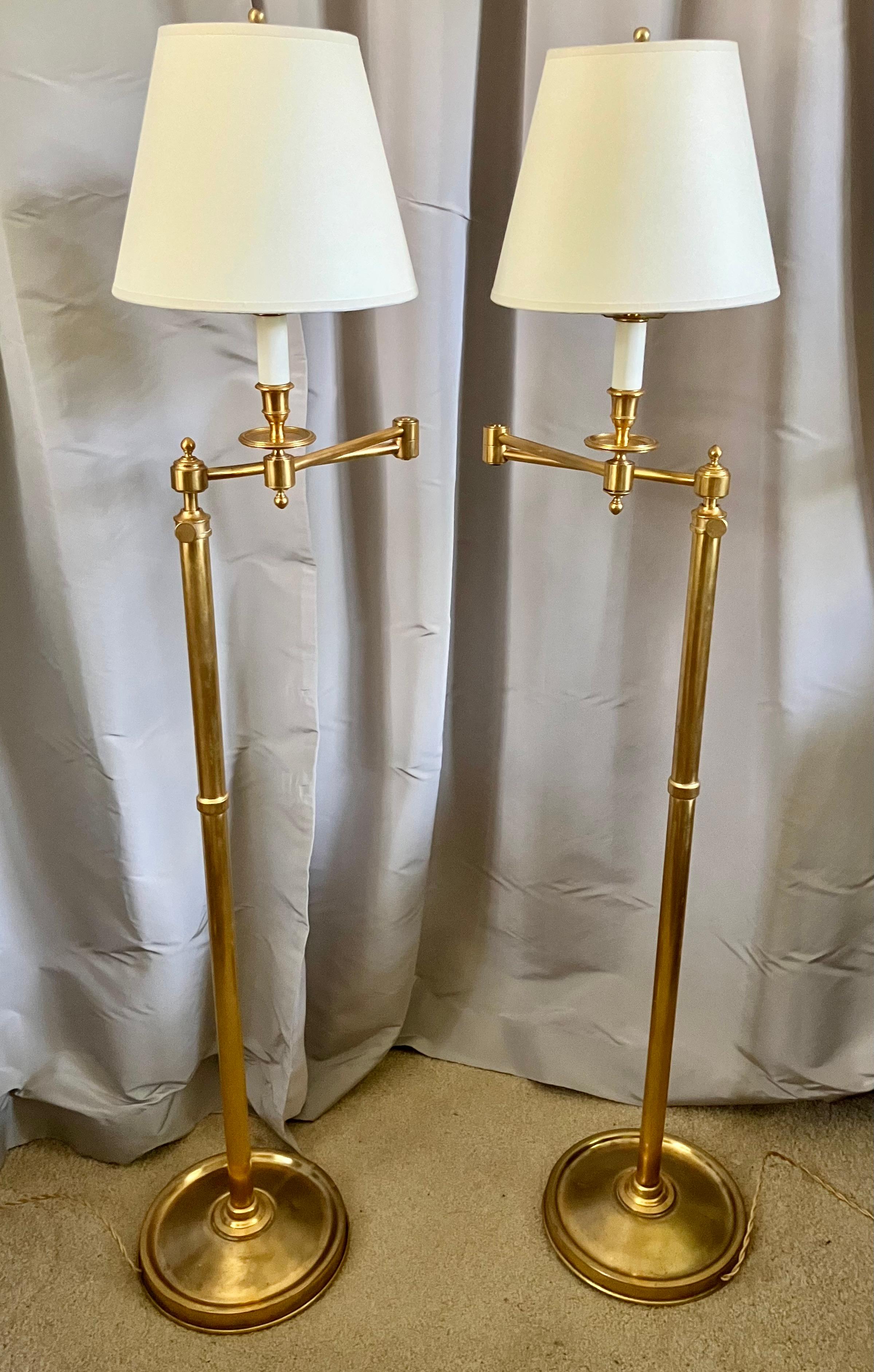 Paire de lampes de lecture à bras pivotant de style Maison Jansen. Lampadaires télescopiques à bras pivotant en laiton doré, nouvellement électrifiés avec cordon de soie et interrupteurs. 

Dimensions : 9
