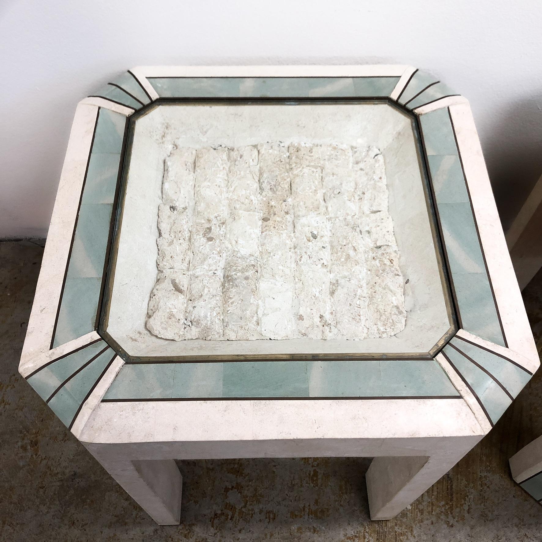 Pair of tessellated stone clad side tables by Maitland Smith. Made in the 1980s these stunning pieces have brass inlay detailing, and a glass top to each protecting and internal stone feature.