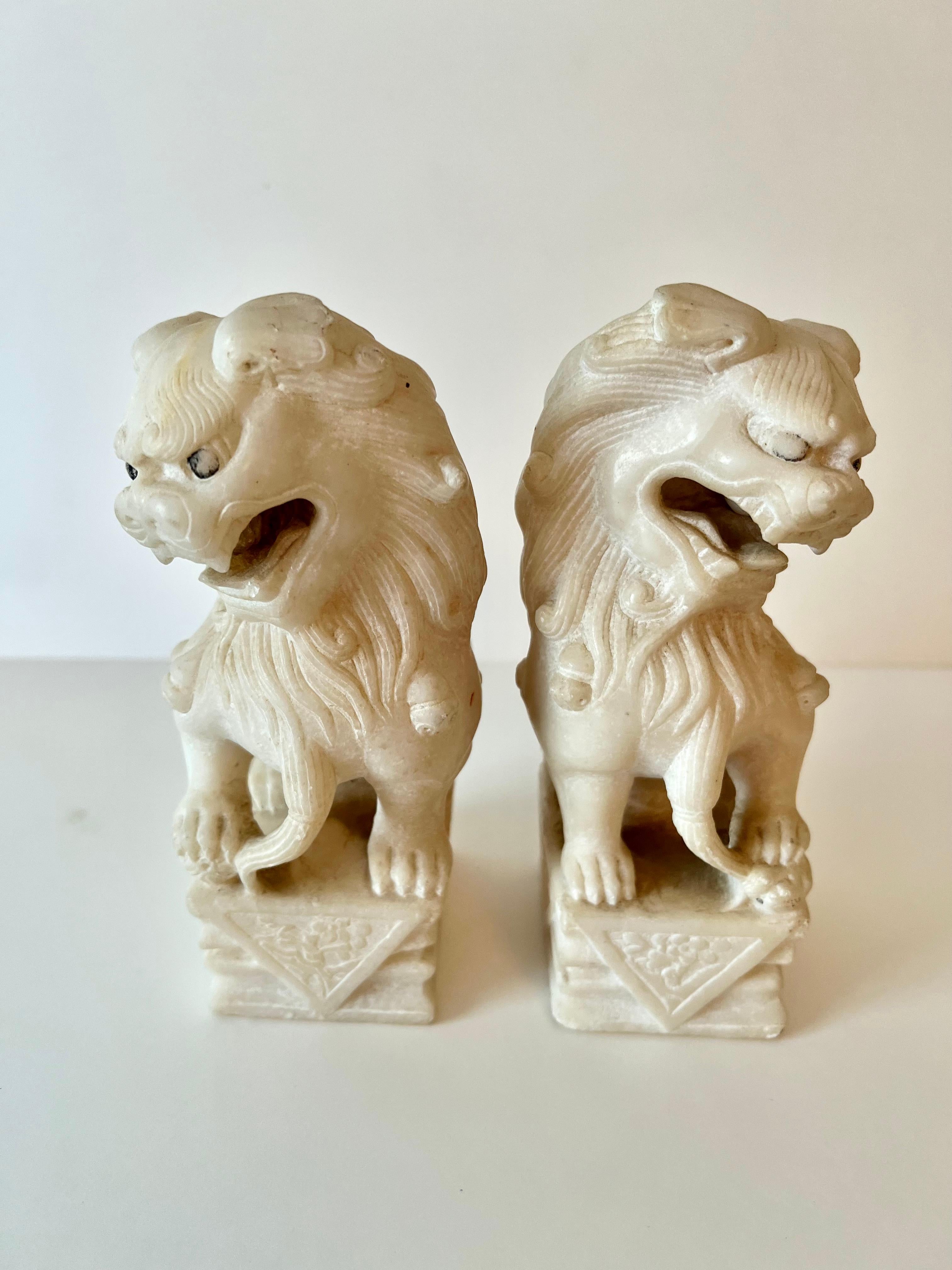 Pair of Vintage Foo Dogs made of Marble - both are of nice weight and can also serve as either bookends, or paperweights.

The age and years of use they have done well, but have some lovely patination as well.