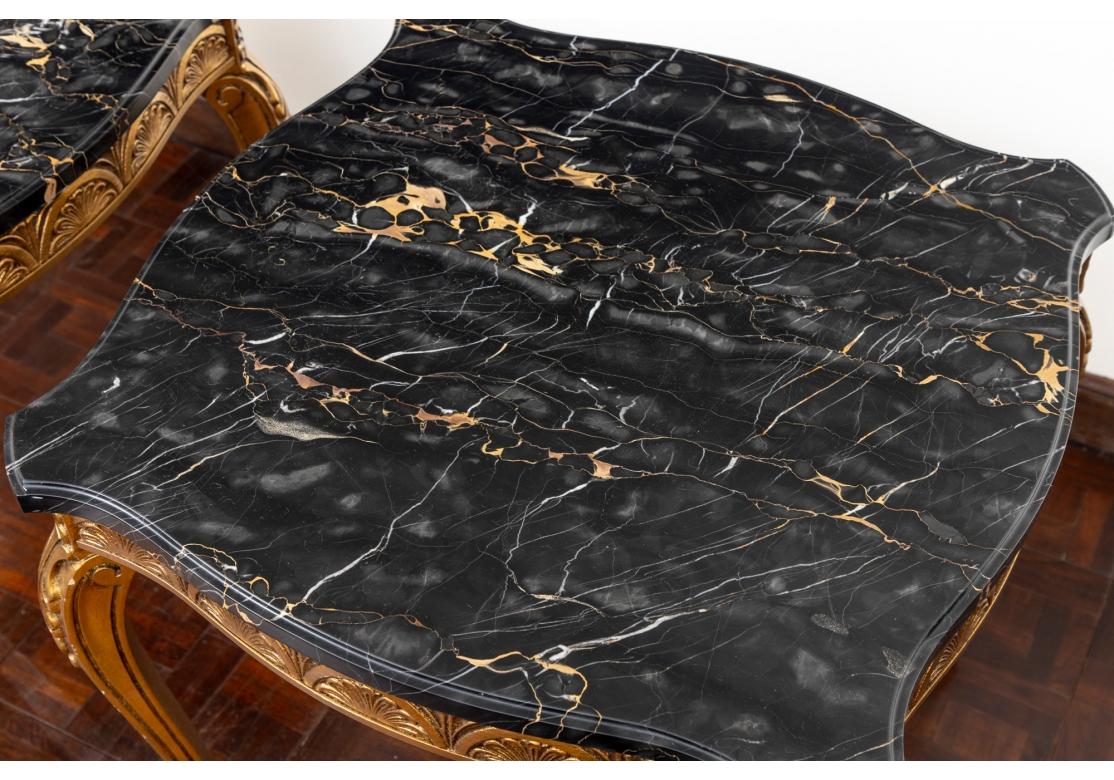 The shaped tables with gilt frames, an elegant band of palmettes along the frieze, and a palmette above acanthus leaves on the scrolled cabriole legs. With fine black marble conforming tops.
Measures: 24 x 24