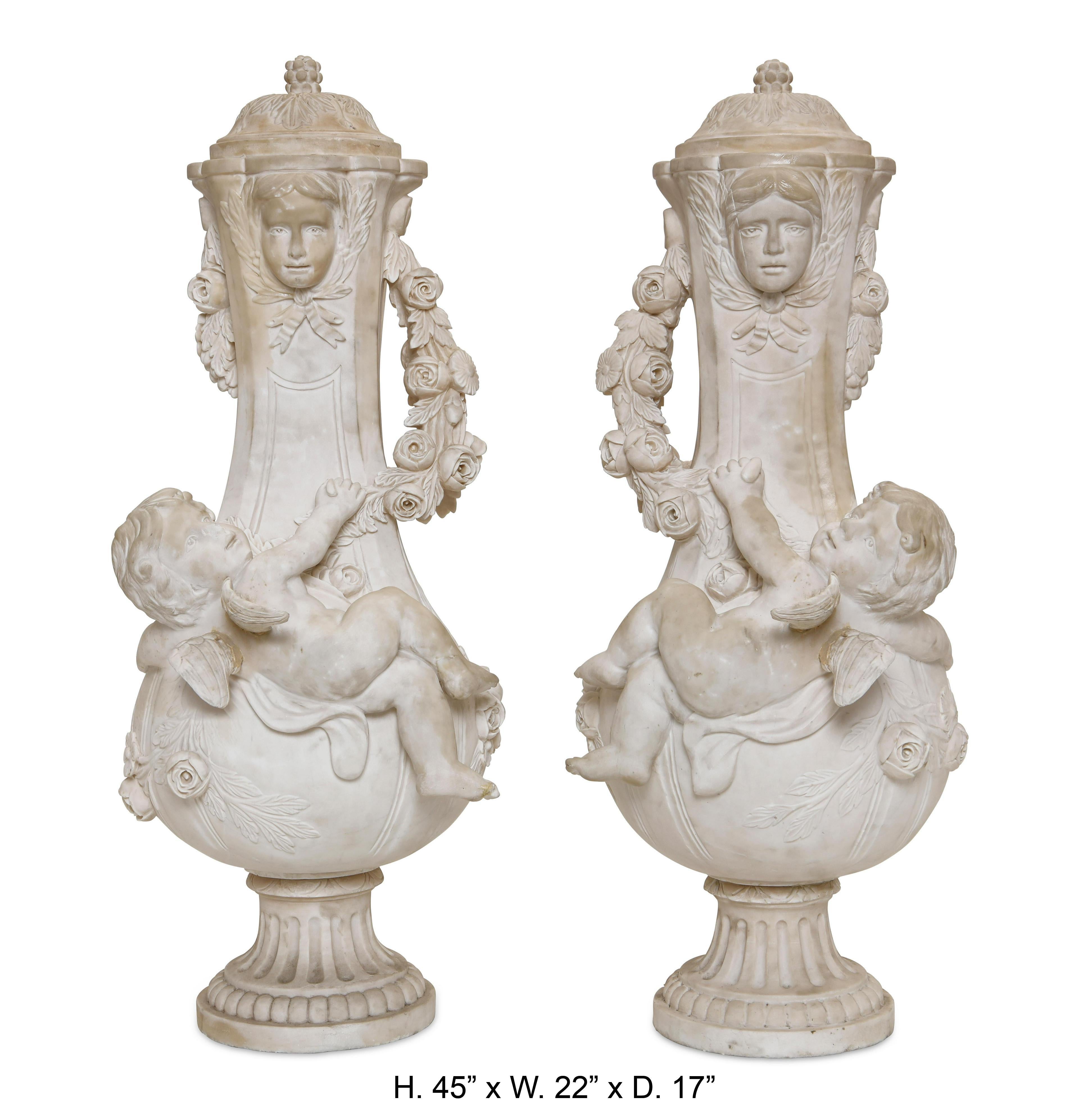 Impressive large pair of French Louis XVI style hand carved white marble urns with cherubs, signed A.Moreau.
Highly attractive and very decorative. 
late 20th century
overall in good condition with some minor repairs
Measures: Height 45in, width
