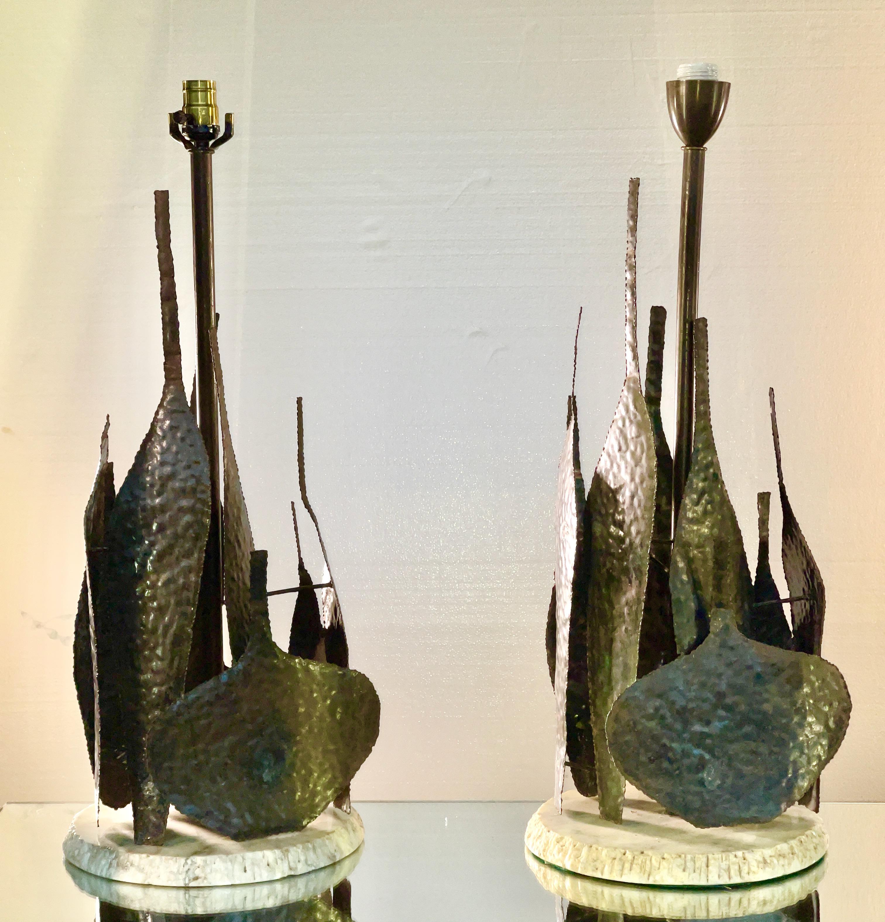 Marcello Fantoni (italien, 1915 - 2011) paire de lampes sculpturales des années 1950 en bouteilles de tôle d'acier découpées au chalumeau et patinées sur des bases rondes en marbre à bords ébréchés. 
Marqué 