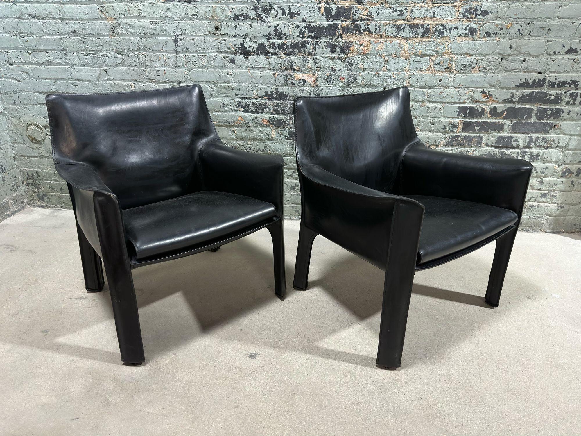 Pair Mario Bellini Black Leather Cab Chairs, Model 414 for Cassina Italy, 1980's.
Chairs are built with tubular steel frames and a thick saddle leather. The leather is kept in place with zippers on inside of the legs. Original condition. Signed by