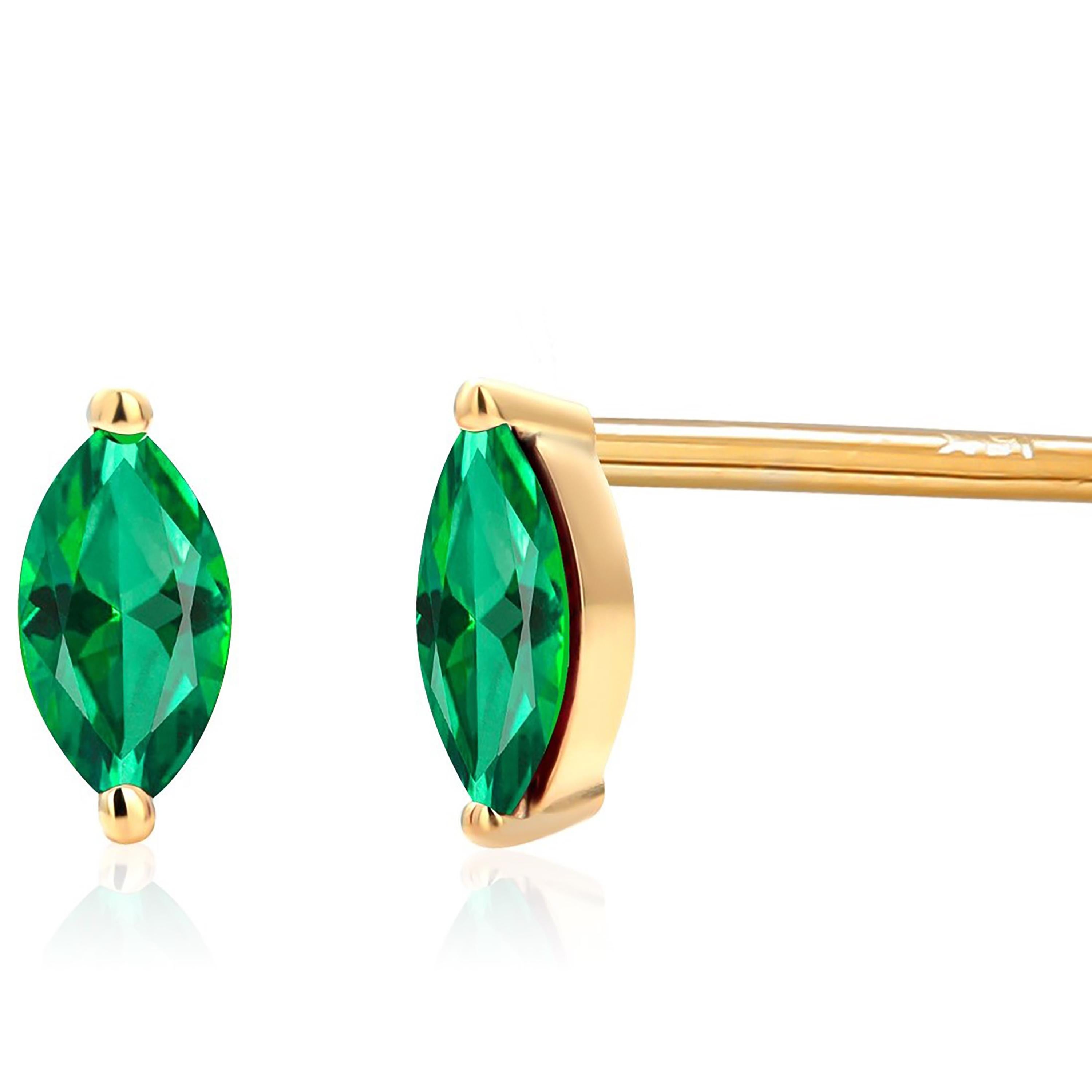 These elegant earrings feature a pair of exquisite Marquise Emeralds, each weighing 0.25 carats, set delicately in 14 karat yellow gold. 
Their petite size, measuring just 0.23 inches in length by 0.15 inch in width makes them perfect for adorning