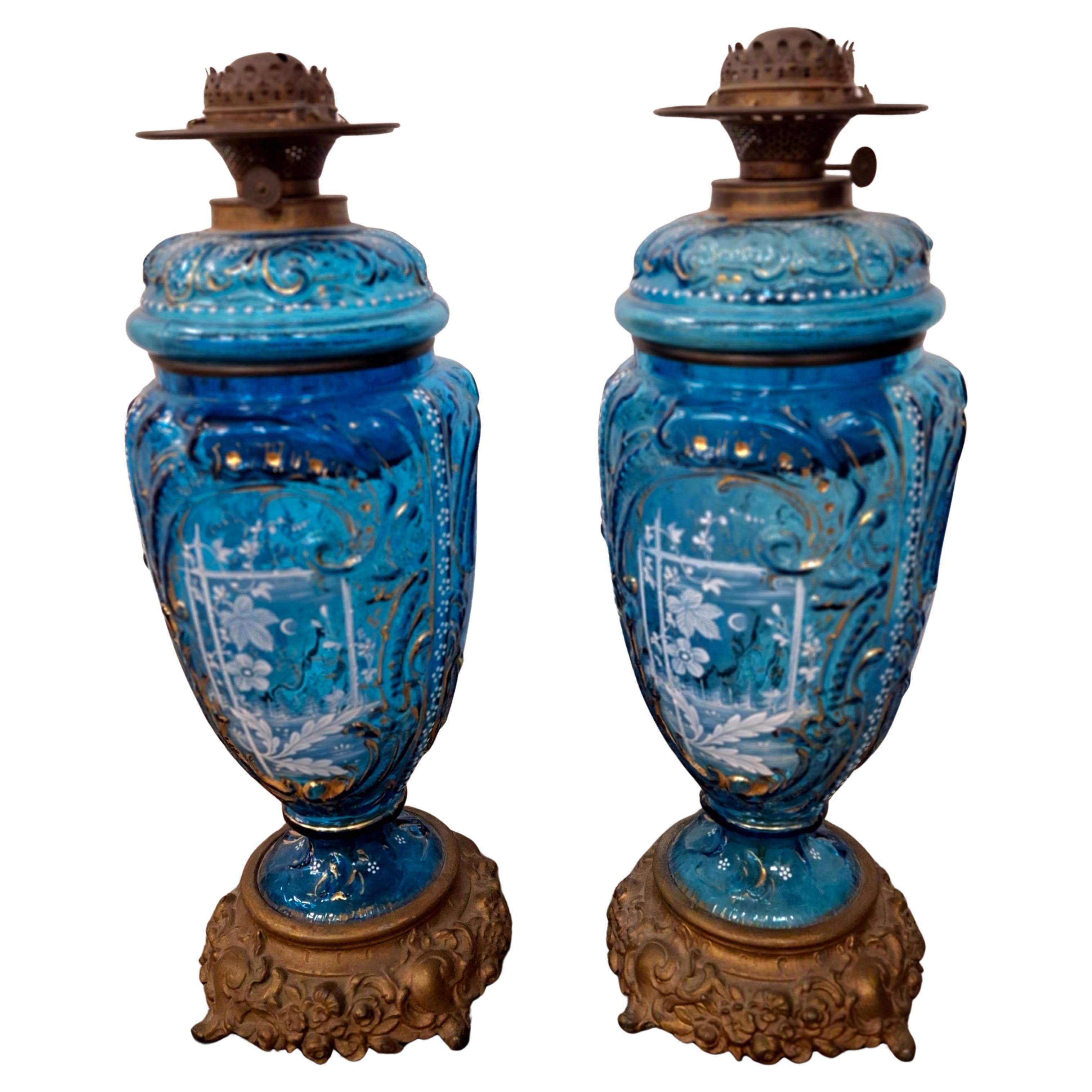 Coppia di lampade ad olio in vetro artistico blu con base in metallo dorato in stile Mary Gregory. Questi possono essere utilizzati solo come vasi, indipendentemente dalle lampade.
Misure: 6