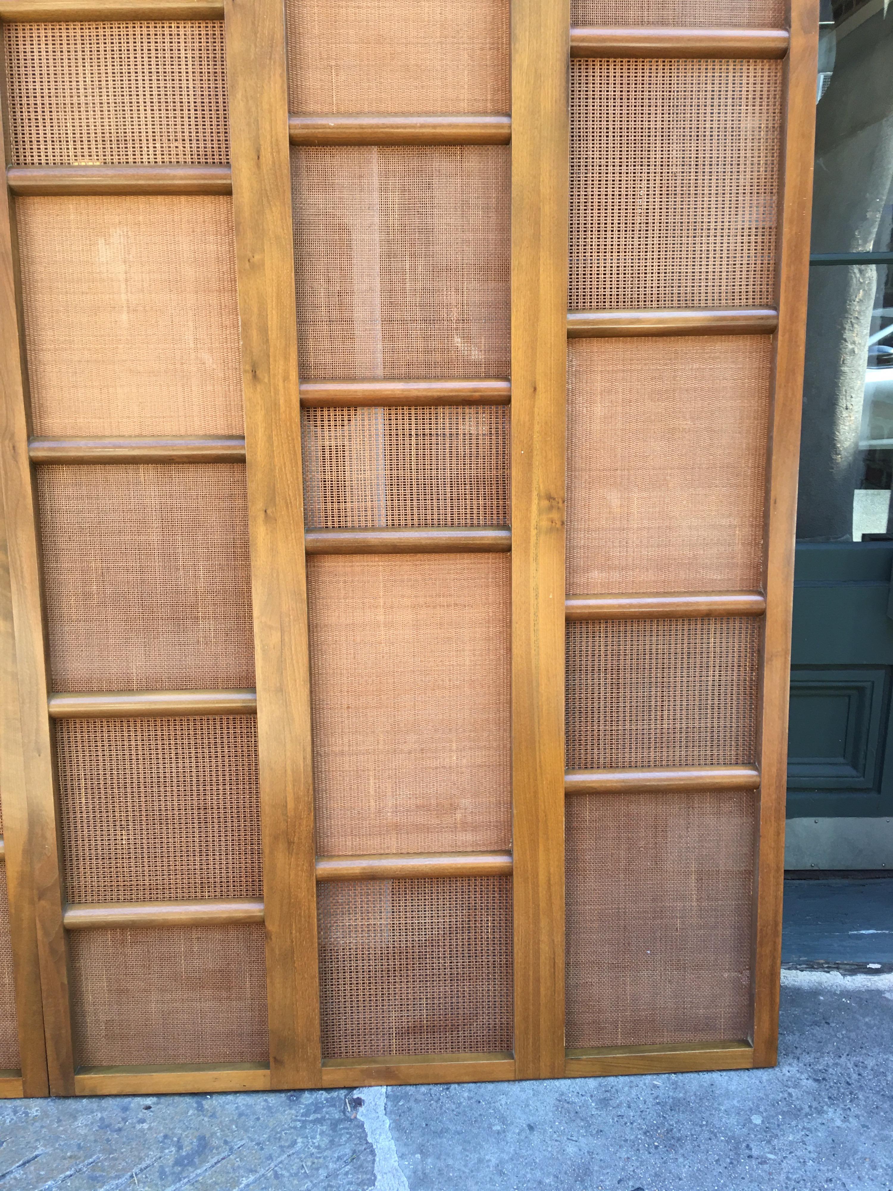 Beautifully made 9 feet high privacy panels from a Newark NJ Office Building designed in the early 1960s. Walnut construction with a variation of caning gives these panels an impressive look! Would be great to join the pair together with hinges to