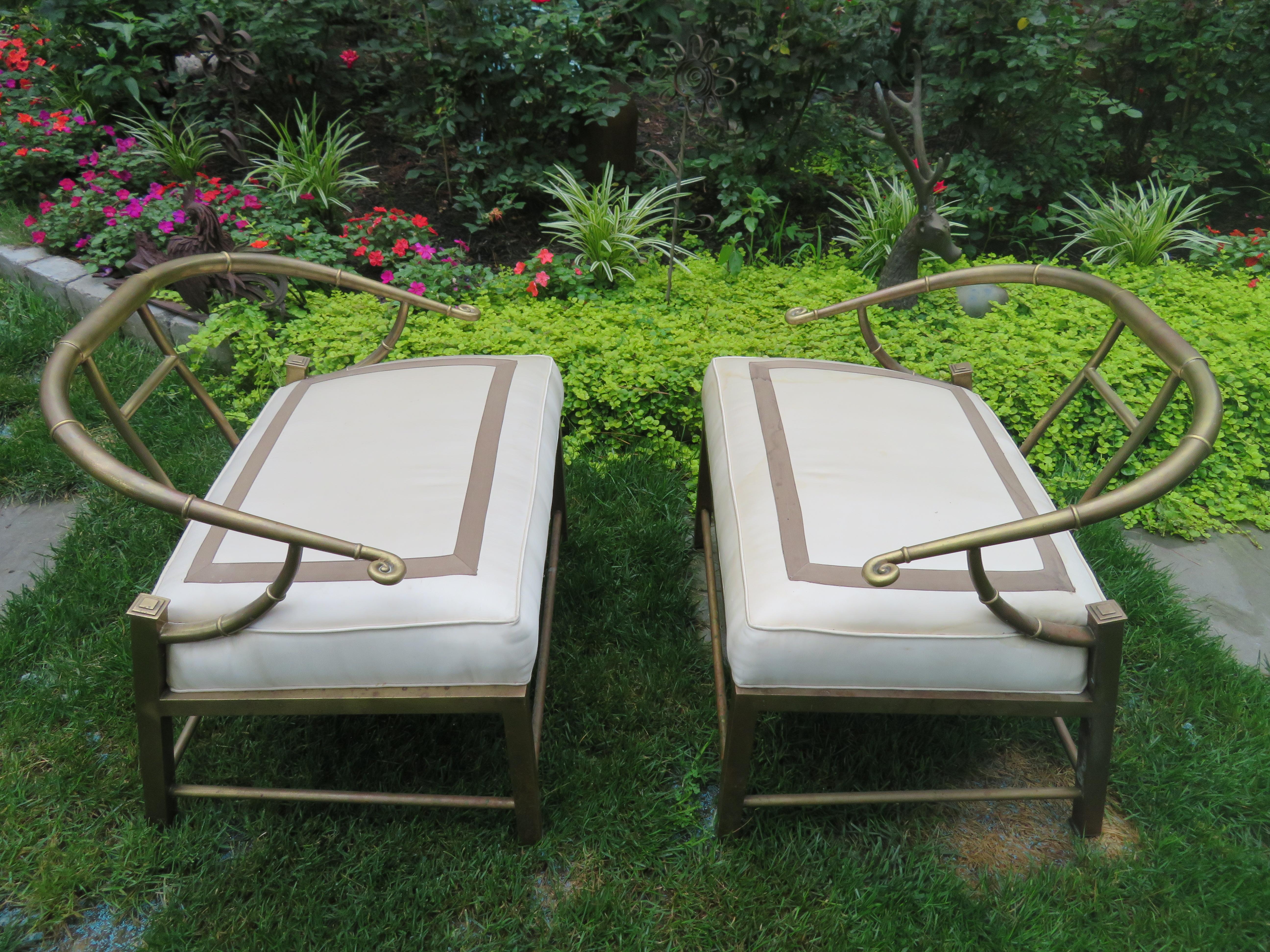 Gorgeous pair Asian-inspired Mastercraft modern lounge chairs with brass frame and vintage cushions. The curved brass arms and back are faux bamboo, with horizontally scrolled hand rests. Brass legs are set at an angle, square in form, and linear in