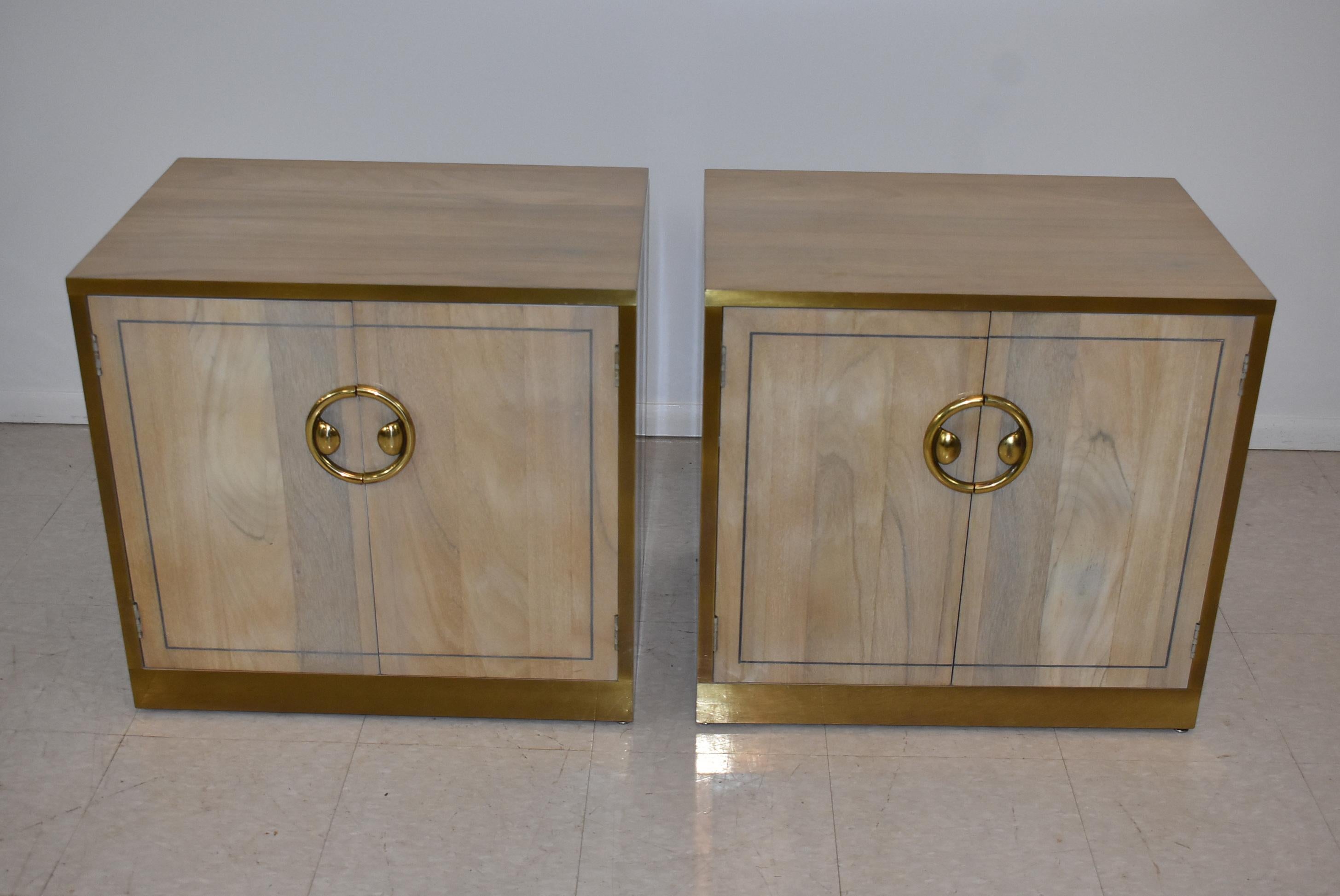 Pair of Zebrano wood and brass nightstands. Banded brass edges with circular brass pull on upper drawer. One adjustable shelf.