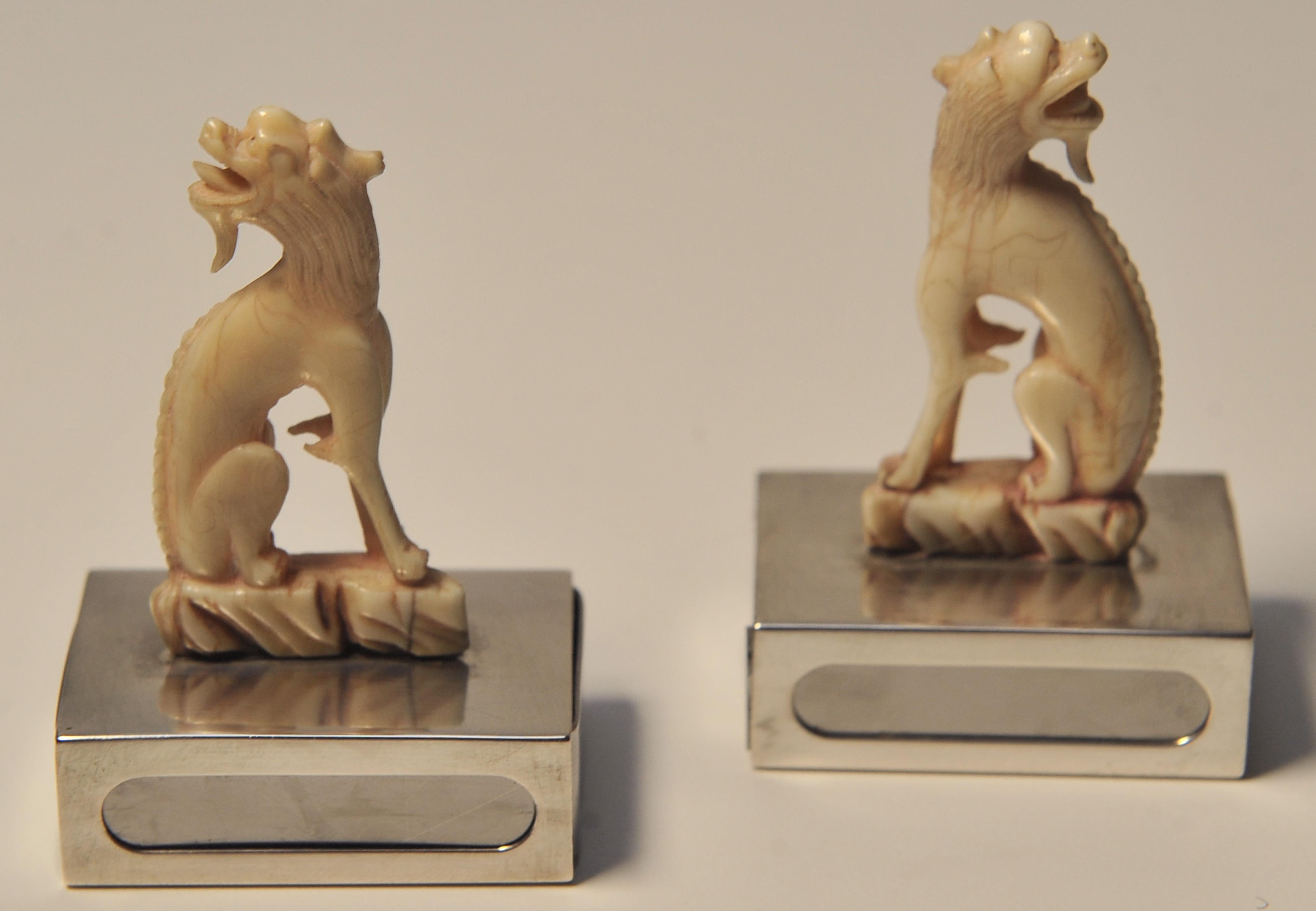 Chinois Paire de porte-bougies assortis ivoire représentant des chiens chinois de Foo et des socles en argent en vente
