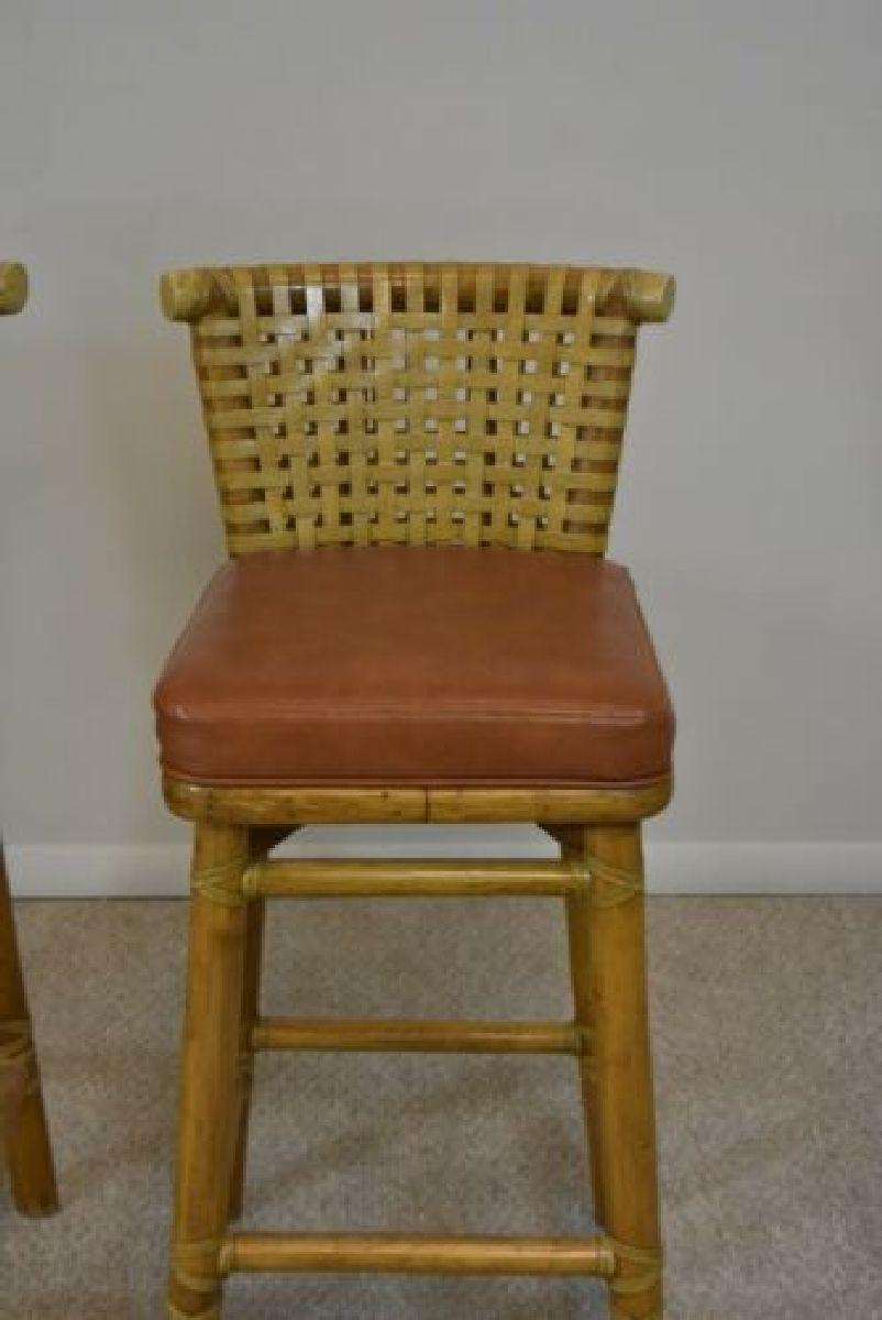Pair McGuire bar stools. The seats have a woven lattice leather rawhide back support with a curved rattan top rail, and a rattan frame. 15