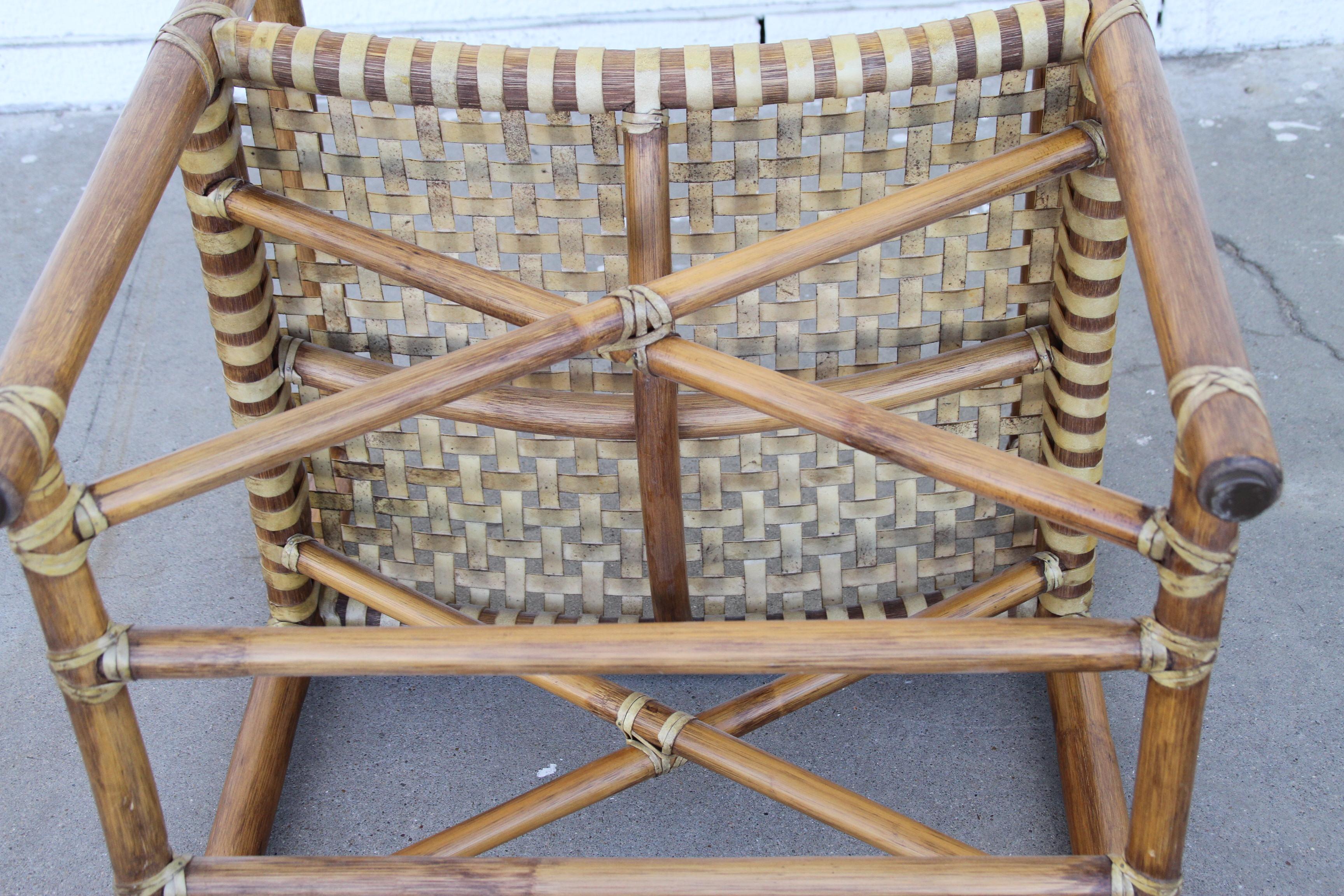 Set of 2 McGuire armchairs featuring lattice style leather seats and back. The model #MCLM45 rattan chair displays a backrest and seat woven in rawhide. X-shaped accents held between four straight rattan legs, connected by a lower rattan stretcher.