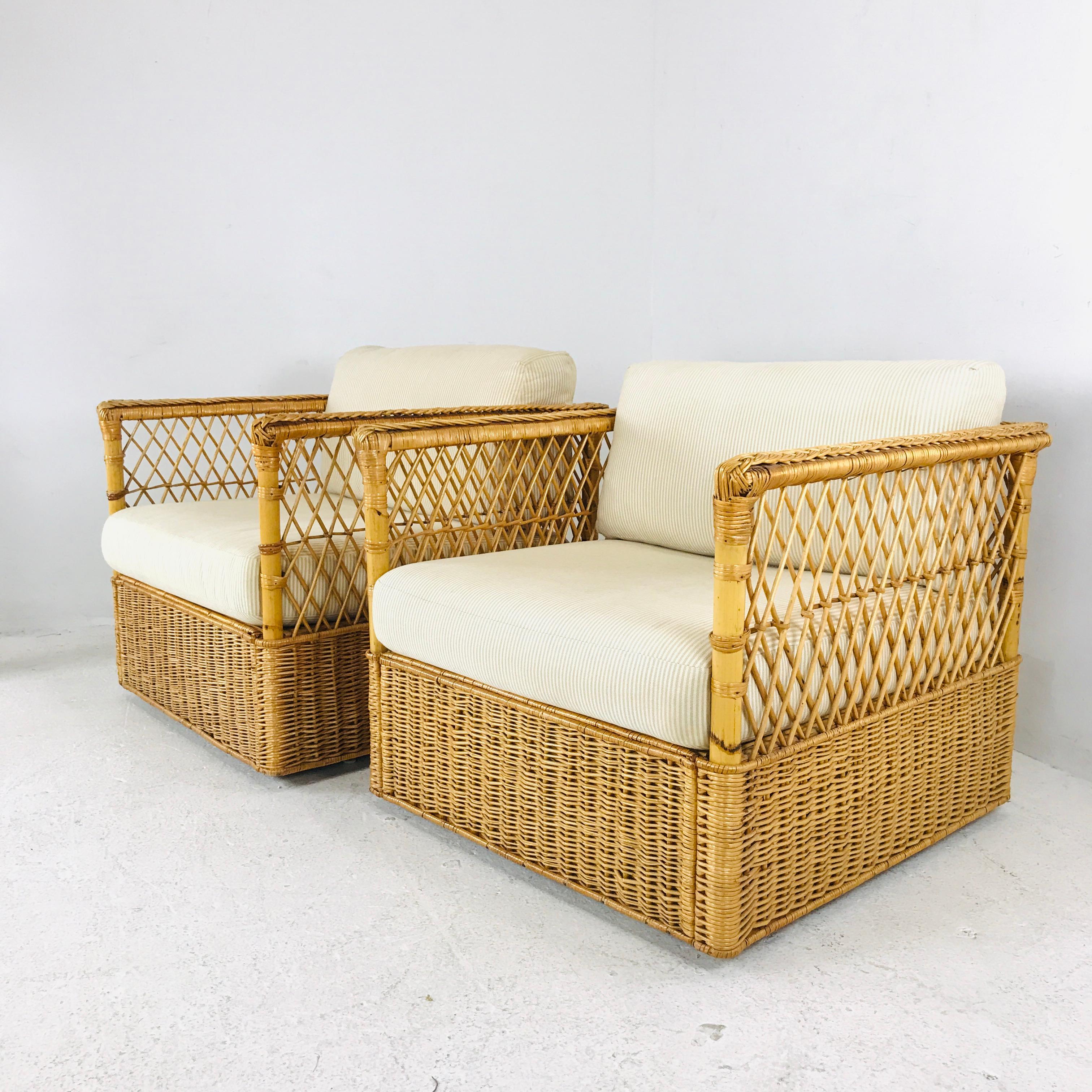Rare pair of organic modern rattan wicker lounge chairs made by McGuire. Features a cube style rattan and wood frame covered with woven wicker. The bottoms have a tight weave pattern while the tops of the side and back have an open fretwork