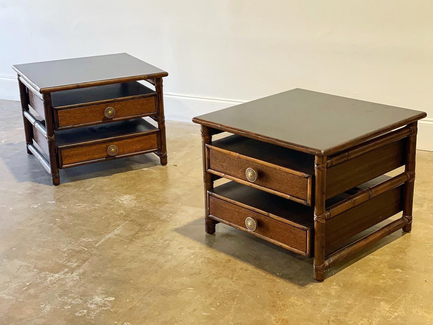Pair of rare and exquisite McGuire oversized side tables with drawers. This set is unique on the market. Rattan and rawhide frames with black formica tops and solid brass pulls. Finished backs with open cubby storage. These tables pack a design