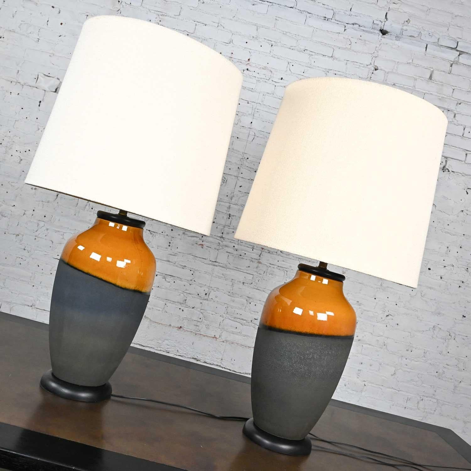 Stunning vintage mid-century modern black matte and gold asymmetrical glazed design floor vase style large scale table lamps with off-white linen-look hard backed drum shades and round wood bases by Carstens Tonnieshof Germany. Beautiful condition,