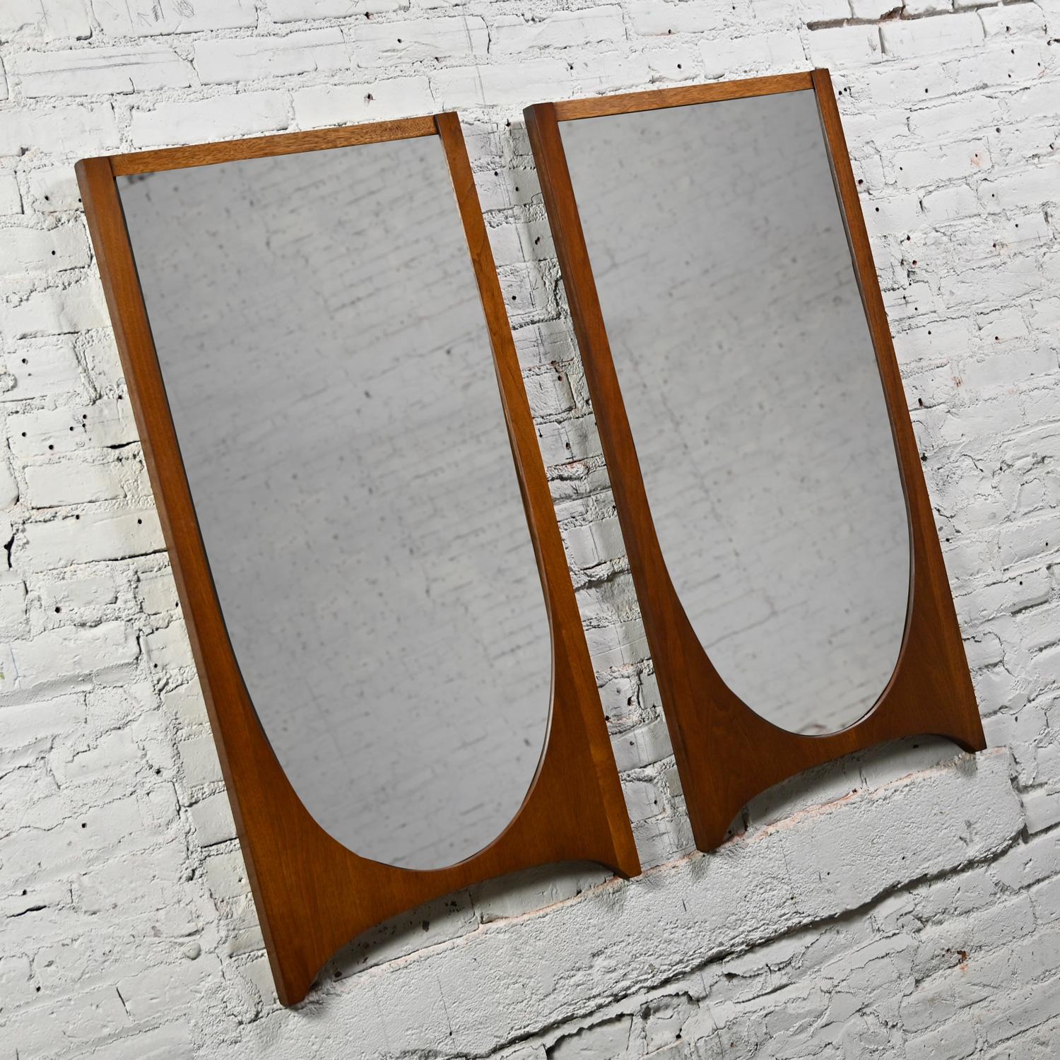 Stunning Mid-Century Modern Brutalist Brasilia single arch mirrors #6130-01 Broyhill Premier Series comprised of walnut, a pair. Beautiful condition, keeping in mind that these are vintage and not new so will have signs of use and wear. This piece
