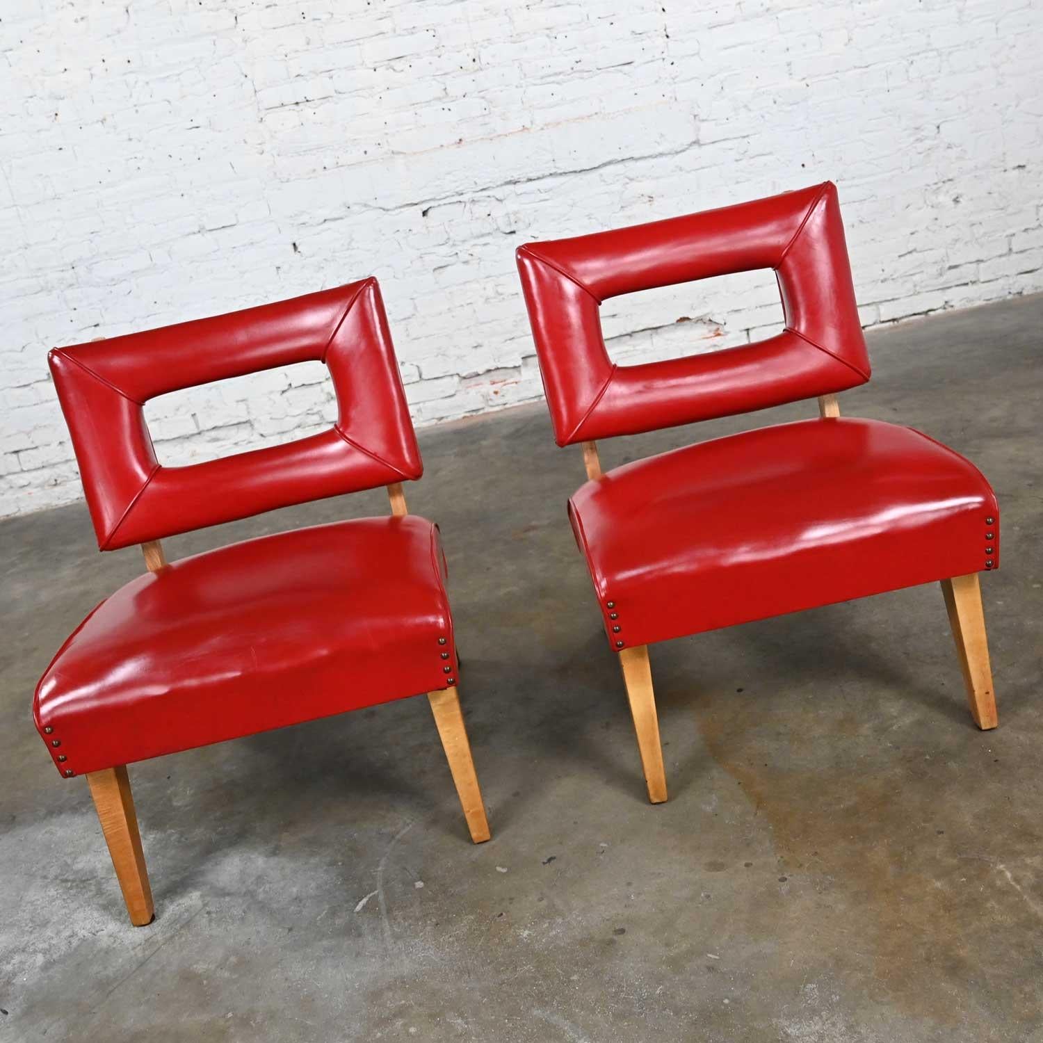 Stunning vintage MCM (a.k.a.) mid-century modern red slipper chairs attributed to Viking Artline, a pair. Comprised of coil springs under the seats, straight, tapered natural oak legs in the front, angled outward in the back, original vinyl or red