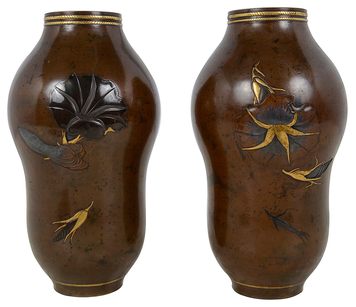 A very stylish pair of Japanese Meiji period (1868-1912) patinated bronze overlay vases, having wonderful exotic flowers with gilded high lights.