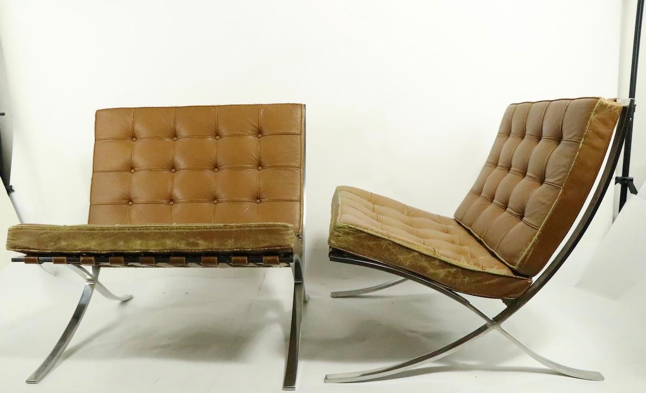 Impressive pair of Knoll (Park Ave.) Barcelona chairs in wonderful baseball glove worn brown leather. Designed by Ludwig Mies van der Rohe, the Barcelona chair practically singularly defined modern furniture. Hard to find existing original pairs,