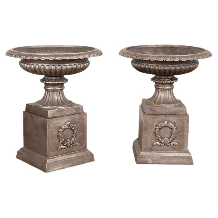 Pair, Mid-20th Century Cast Iron Planting Urns Resting on Square Plinth For Sale