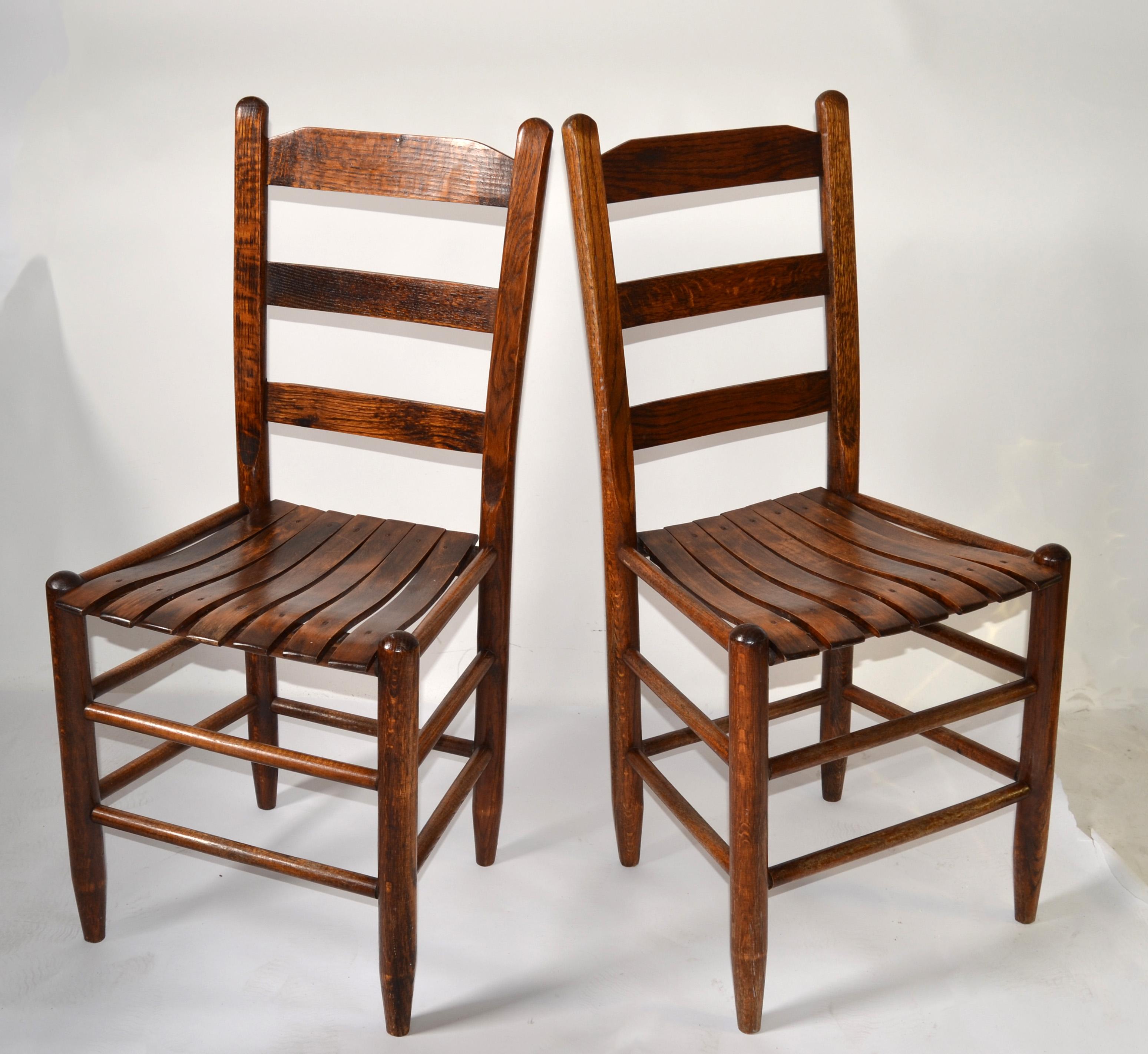 Paire de chaises d'appoint, de bistro ou de salle à manger en chêne rustique, faites à la main, dans le style de Charlotte Perriand et de la période moderne du milieu du XXe siècle.   
Ce fauteuil en bois de chêne massif est doté d'un dossier en