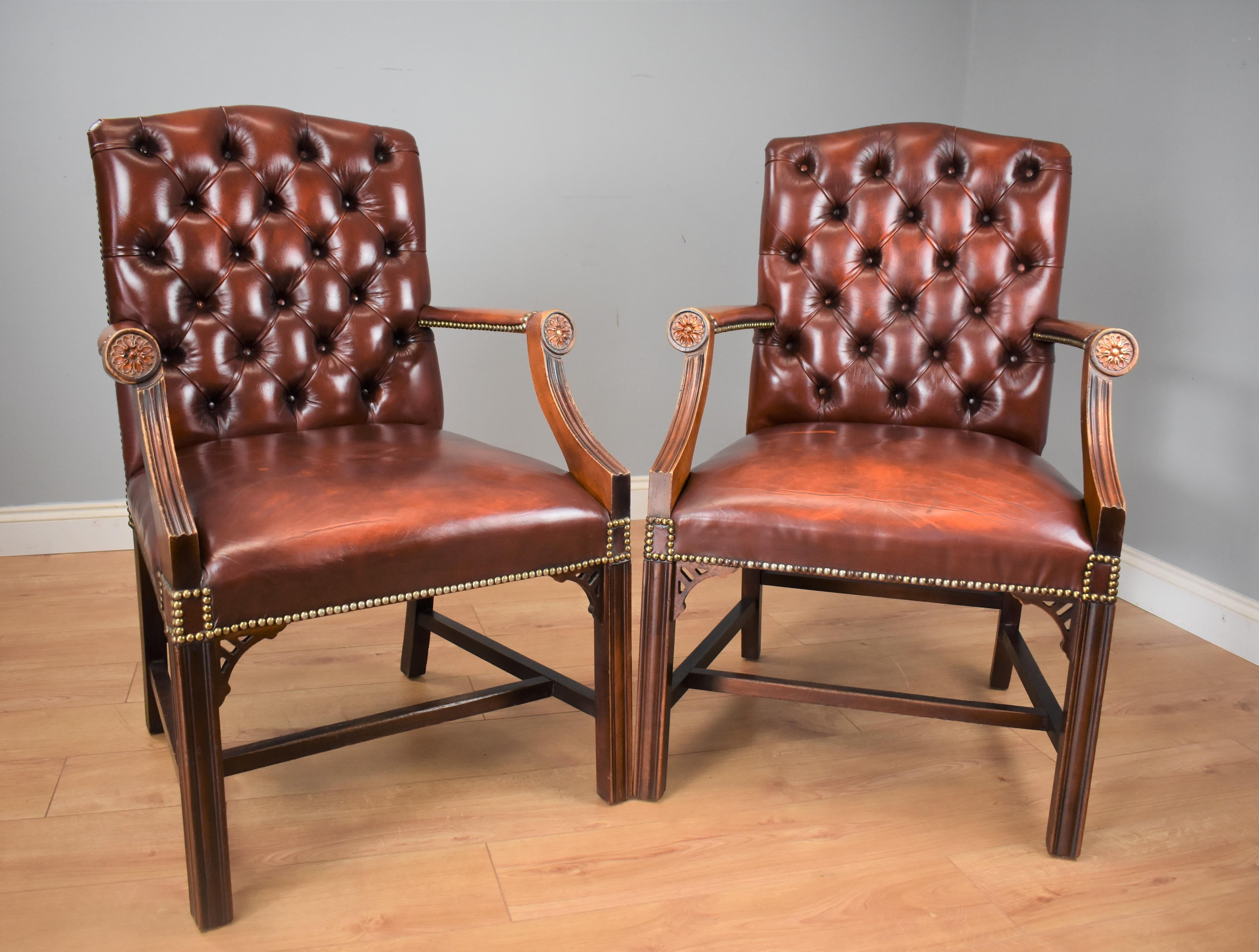 For sale is a pair of mid-20th century leather Gainsborough library chairs having deep buttoned backs with brass studded edges. The solid mahogany frame standing on square legs united by a stretcher. 

Dimensions:
 Width 26