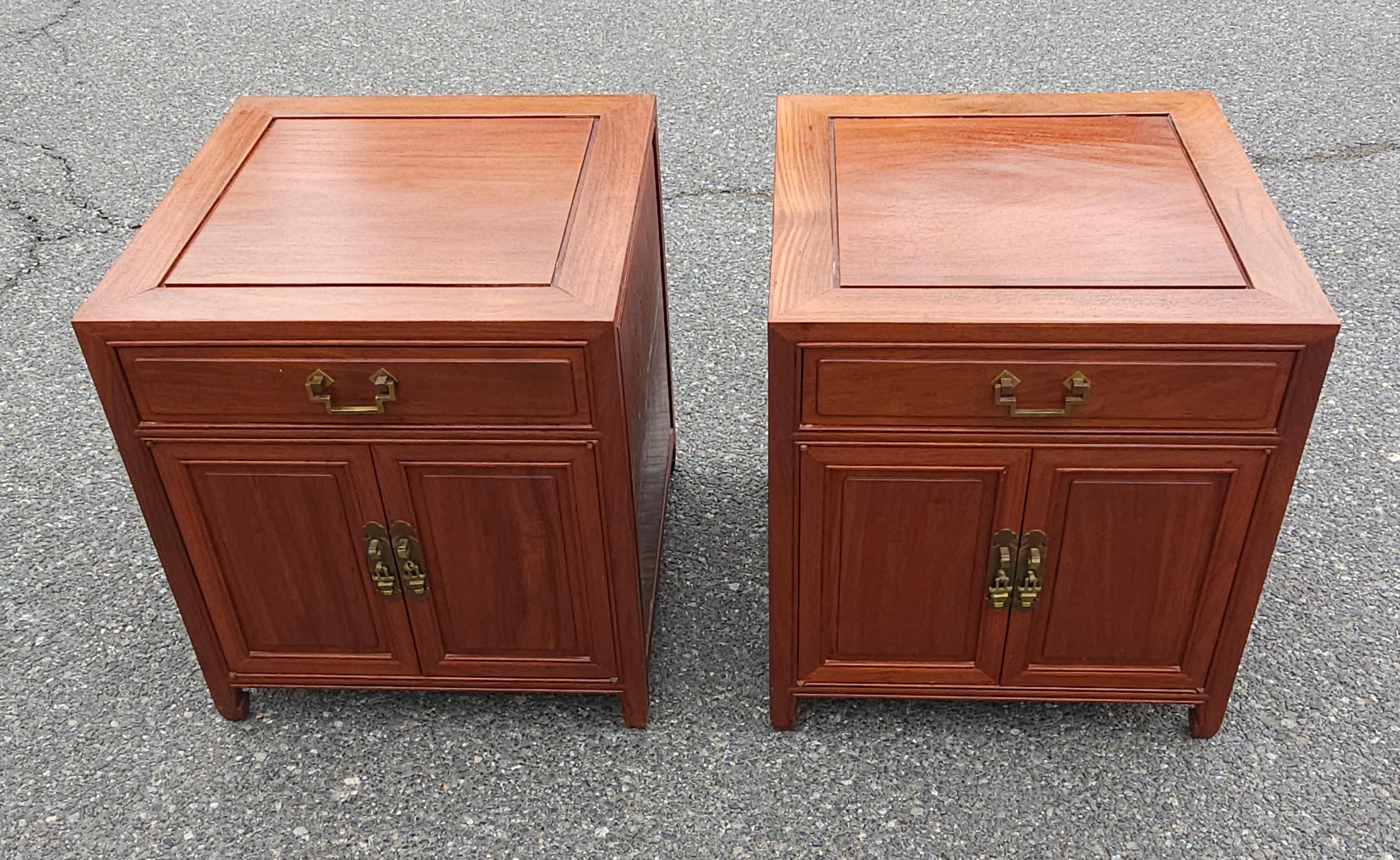 An exquisite Pair of Mid 20th Century Ming Style Rosewood Side Table Cabinets with protective Glass Tops. Pristine vintage condition with very light signs of use.
Feature  a single top drawer and two-door bottom cabinet with a removable