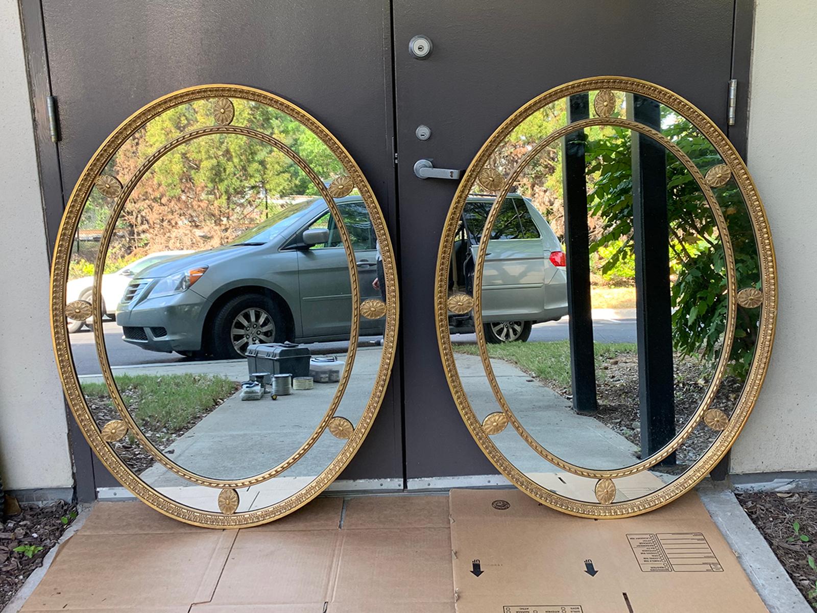 Pair of mid-20th century oval giltwood George III style oval mirrors, circa 1970s.