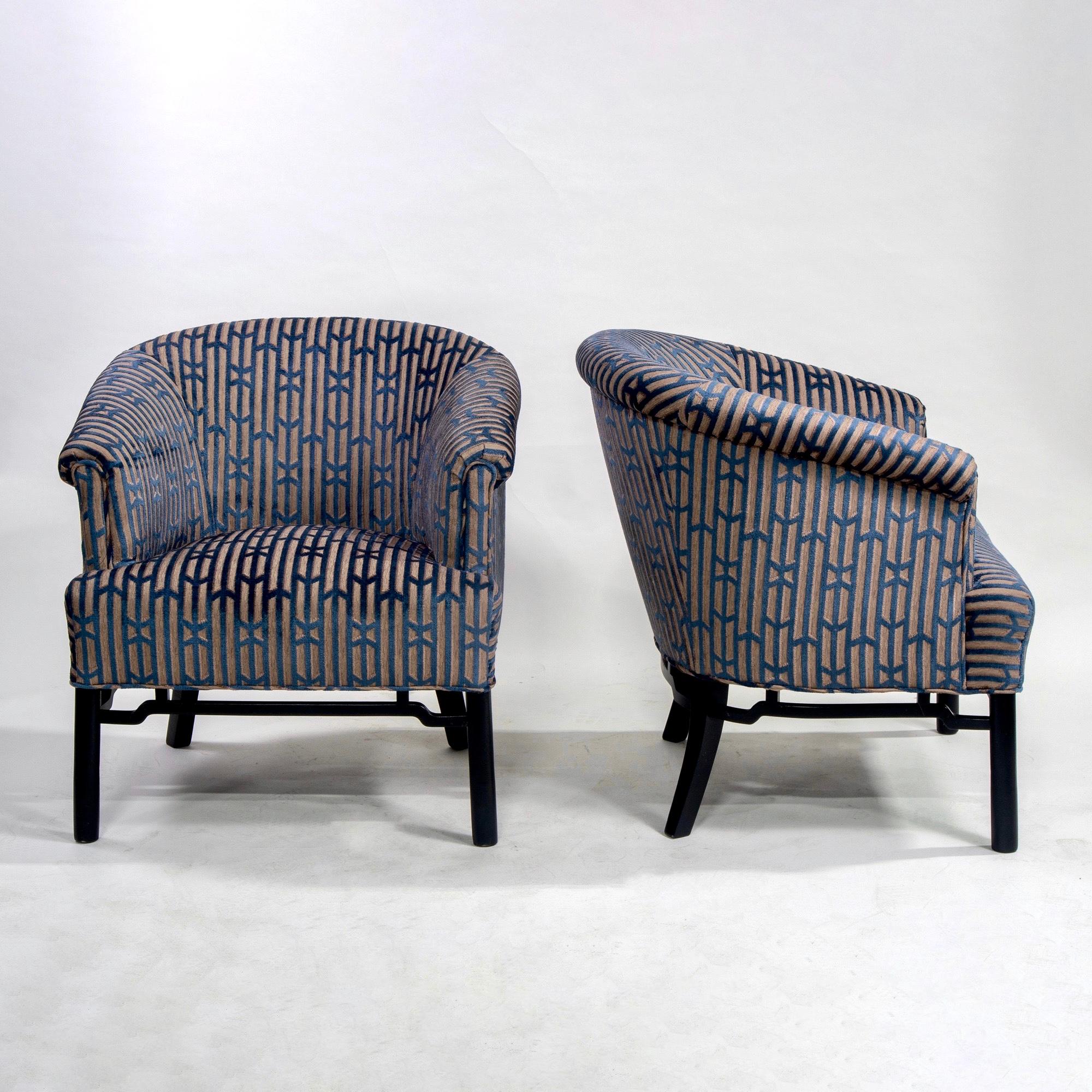 Pair circa 1960 Baker Furniture club chairs with new upholstery. Barrel back chairs with slender rolled arms and decorative, black frame and lattice work apron. Fabric is teal blue and taupe chain-pattern chenille. Sold and priced as a pair.