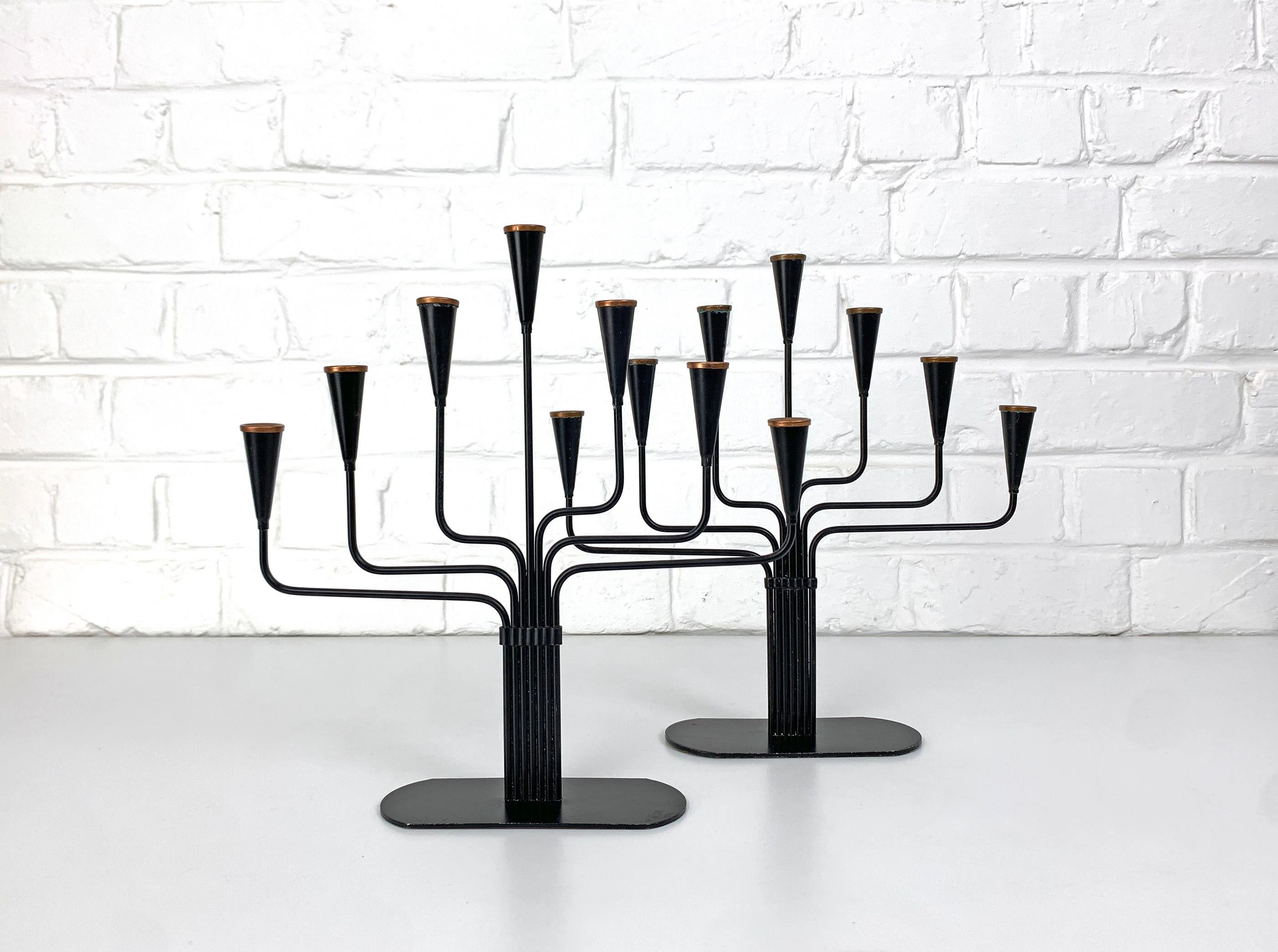Pair of Swedish Modernist candle holders for 7 candles, designed by Gunnar Ander. Produced by Ystad-Metall, located in the town of Ystad in Sweden. 

Made of steel, painted black with copper rings at the top.

Gunnar Ander is a Swedish artist born