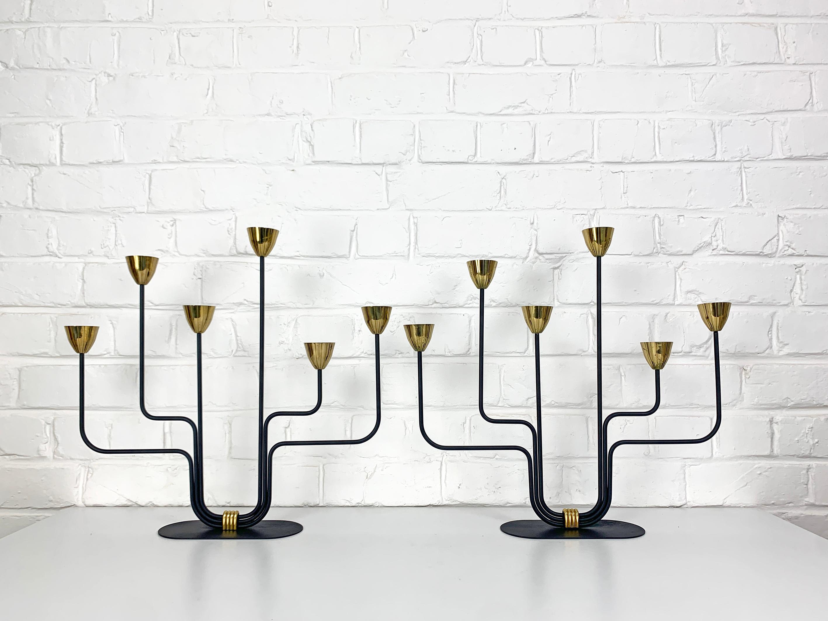 Pair Swedish Modernist candle holders by Gunnar Ander. Produced by Ystad-Metall, located in the town of Ystad in Sweden. 

Stylised flowers in brass on 6 asymmetrical steel arms painted black. This is the big model which is a lot more impressive