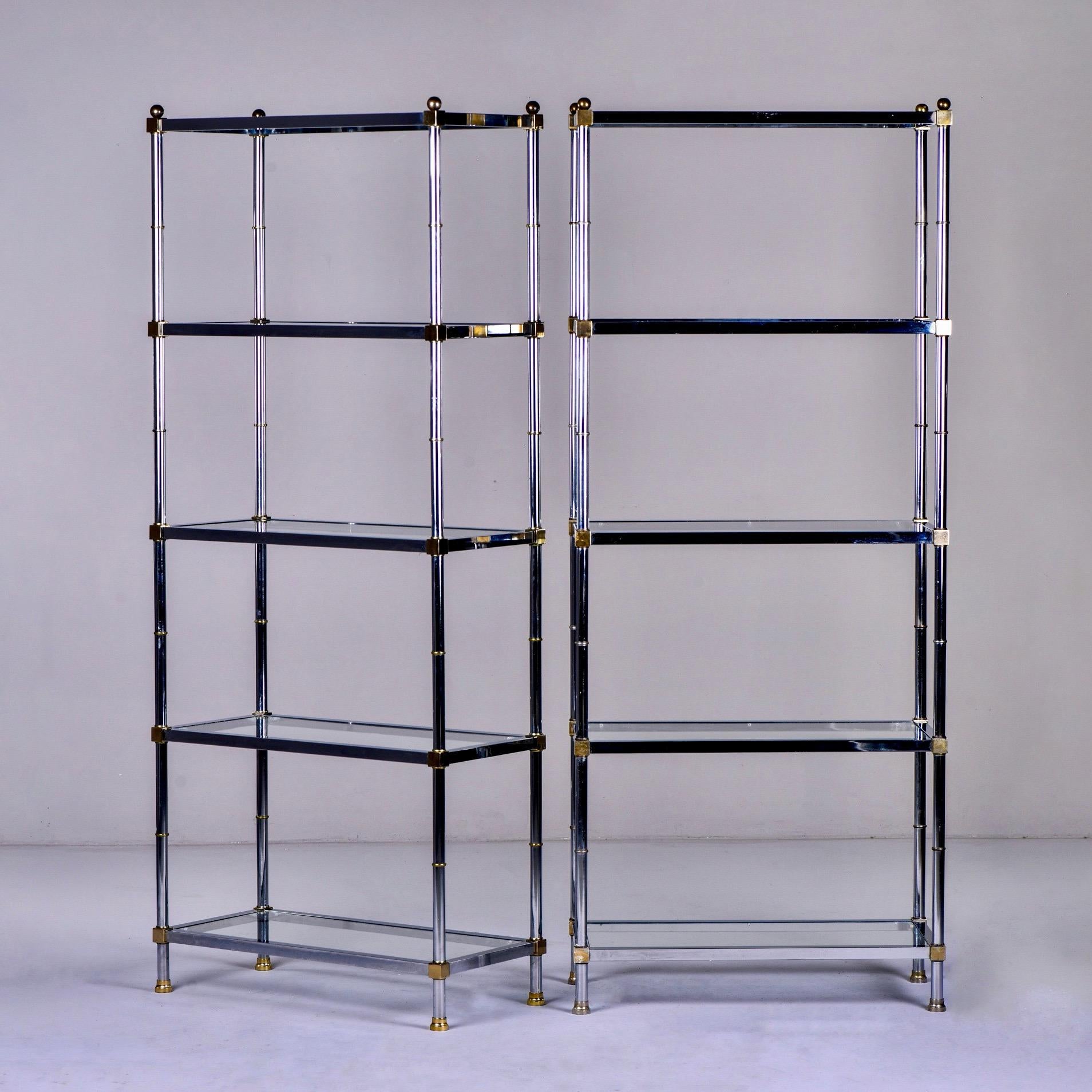Pair of five shelf étagères in chrome and glass with brass-plated accents in manner of Maison Jansen, circa 1970s. Unknown maker. Sold and priced as a pair.