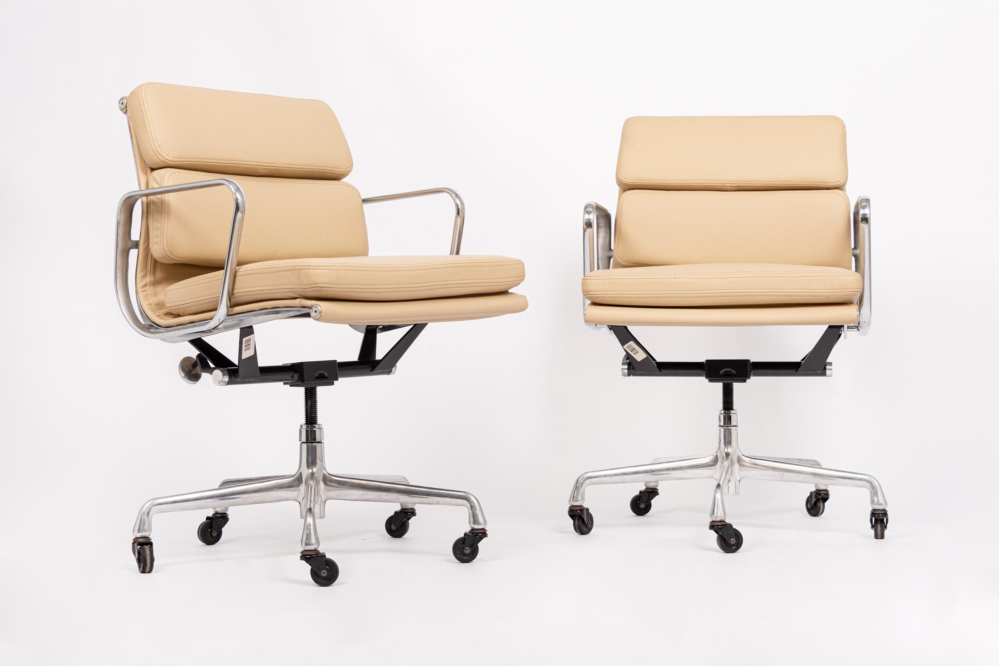 This pair of authentic Eames for Herman Miller Soft Pad Management Height cream leather office chairs from the Aluminum Group Collection were manufactured in the 2000s. This classic mid century modern office chair was first introduced in 1969 by