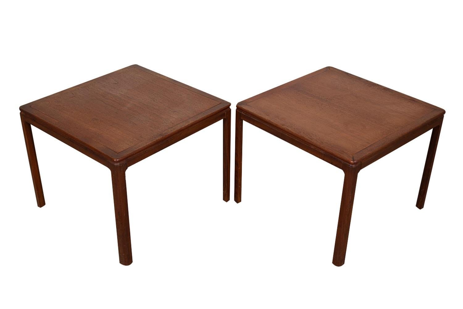 Une belle paire de tables d'appoint de style Parsons par Dux. Les deux sont en bon état. Ce modèle présente un superbe design minimal avec de superbes plateaux de table en teck et des coins arrondis classiques. Chacun d'entre eux repose sur des