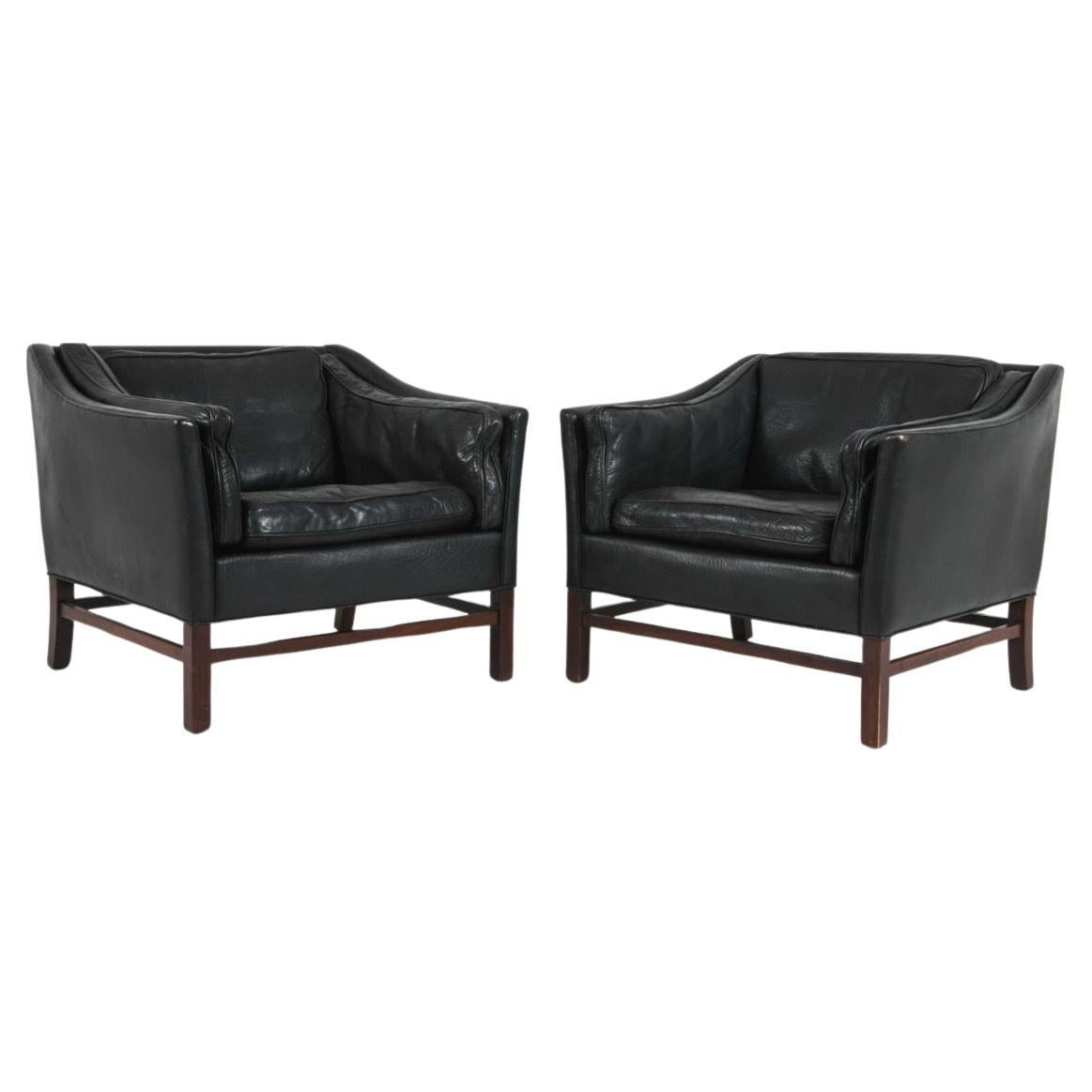 Coppia di sedie da salotto in pelle nera della metà del secolo scorso di Georg Thams  prodotto in Danimarca. Costruito in legno di palissandro massiccio e con l'originale rottura in vera pelle nera, questo design moderno è caratterizzato da