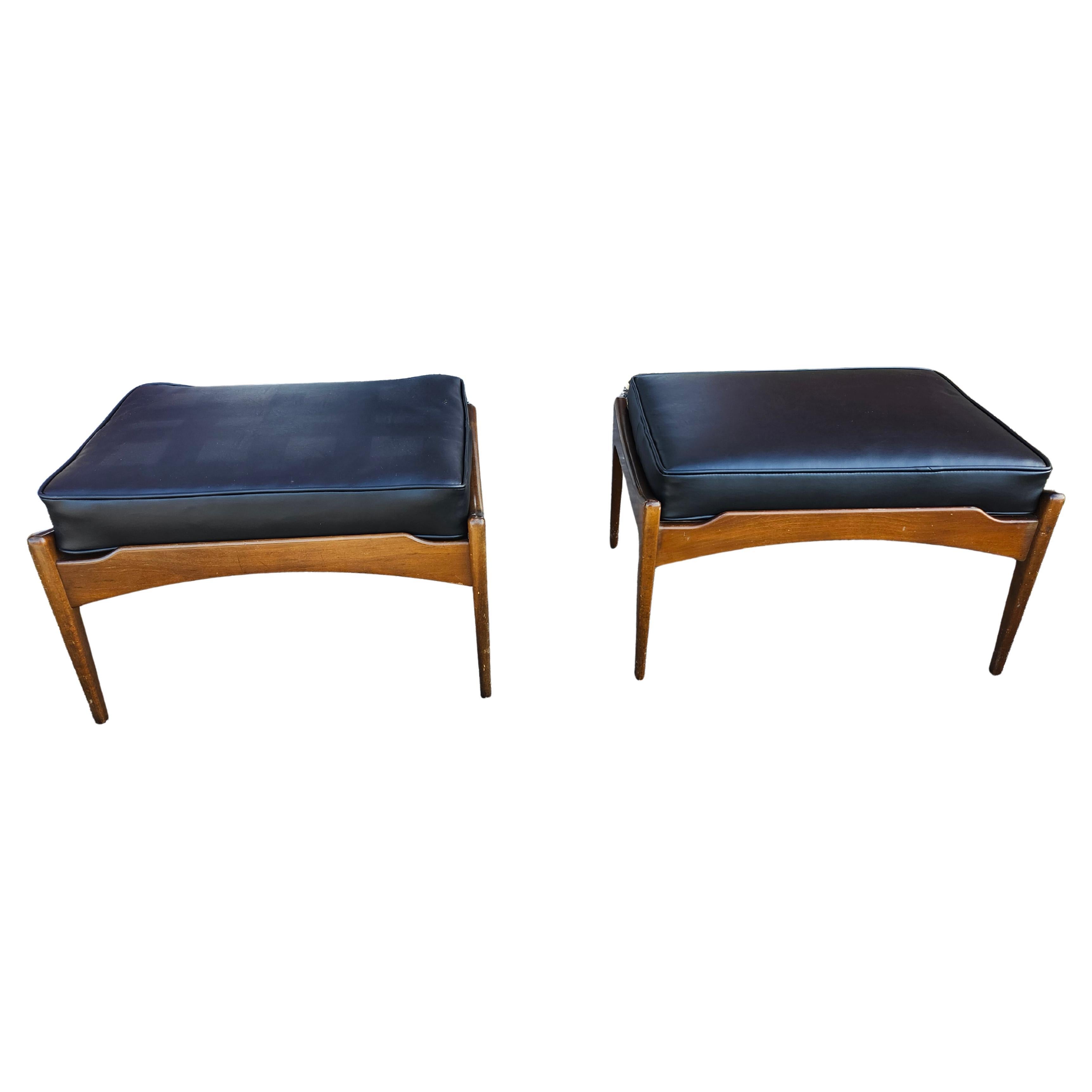 Rare and hard to find as a pair this exceptional pair with new leather cushions and nylon webbing. Walnut frames are tight and sturdy while the finish has a few very minor scuffs.
Signed by Selig with the trademark button. Designed by Ib Kofod