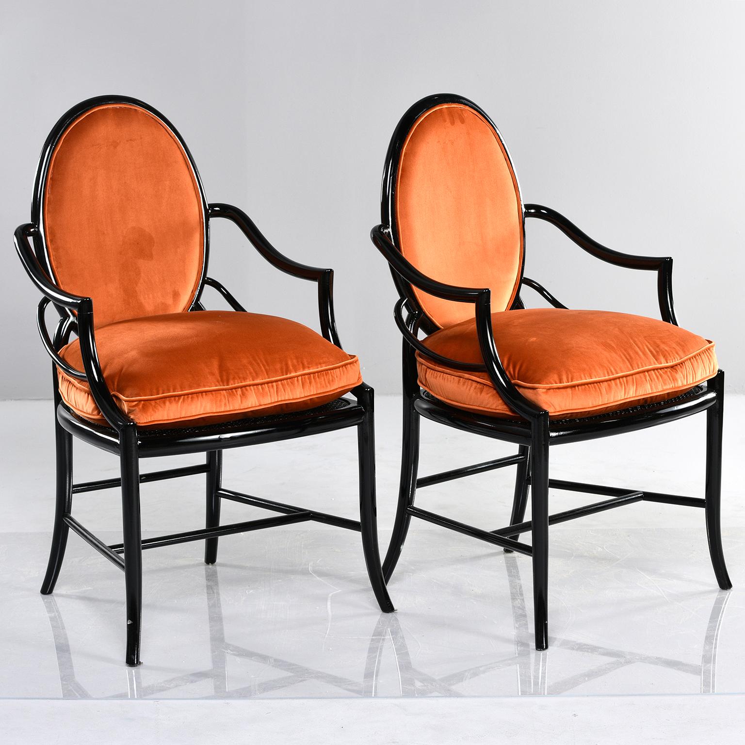 Pair of bentwood armchairs with ebonised finish and caned seats, circa 1950s. Newly upholstered in a pumpkin orange velvet chenille with removable seat cushions. Unknown maker. Found in Italy.

Measures: Arm height 27.5”, seat height 23.5”
Seat