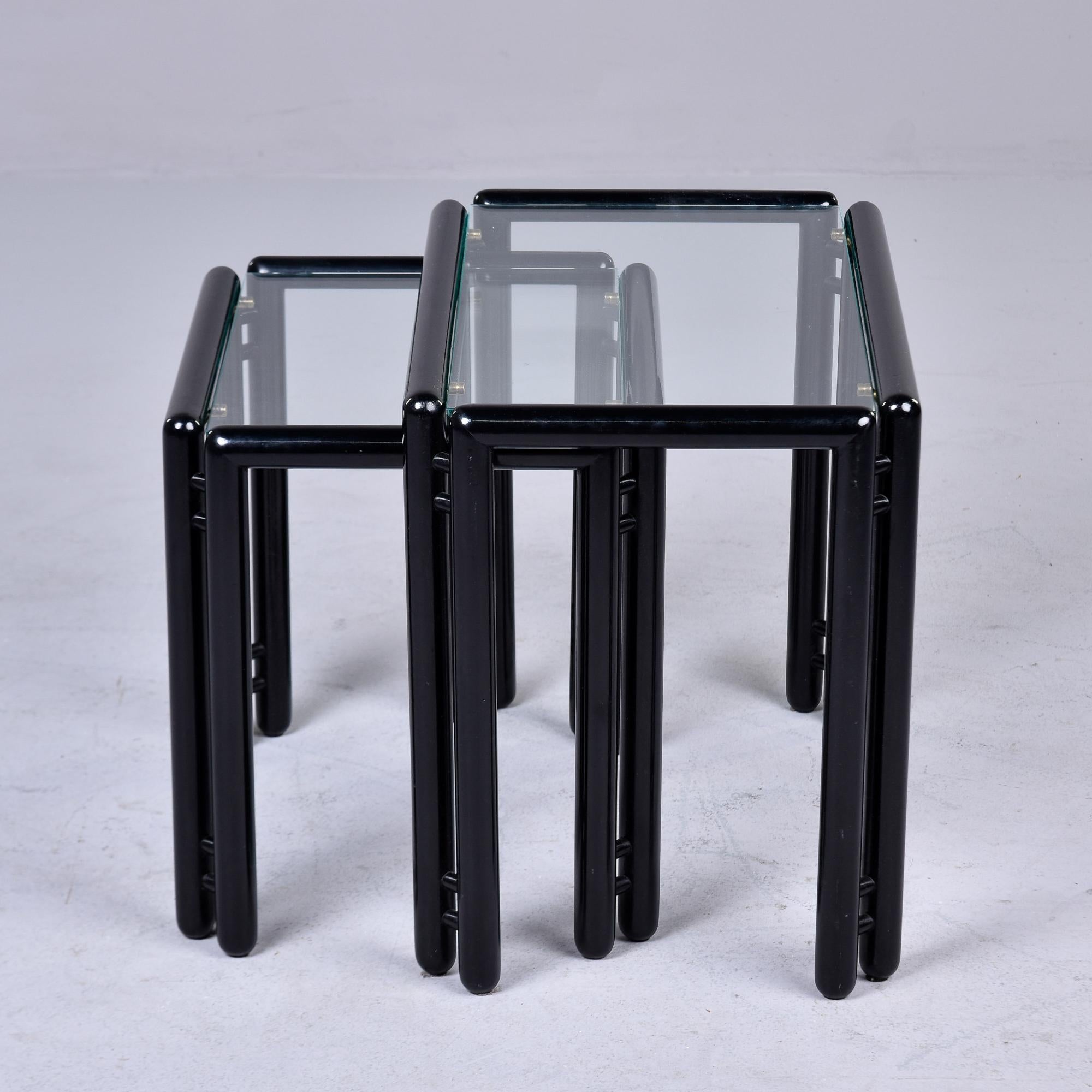 Pair Mid Century Ebonised Stacking or Nesting Tables with Glass Tops 

Found in Italy, these two stacking or nesting tables date from the early 1970s. Wood frames have a glossy black stained or painted finish and clear glass table tops. Unknown