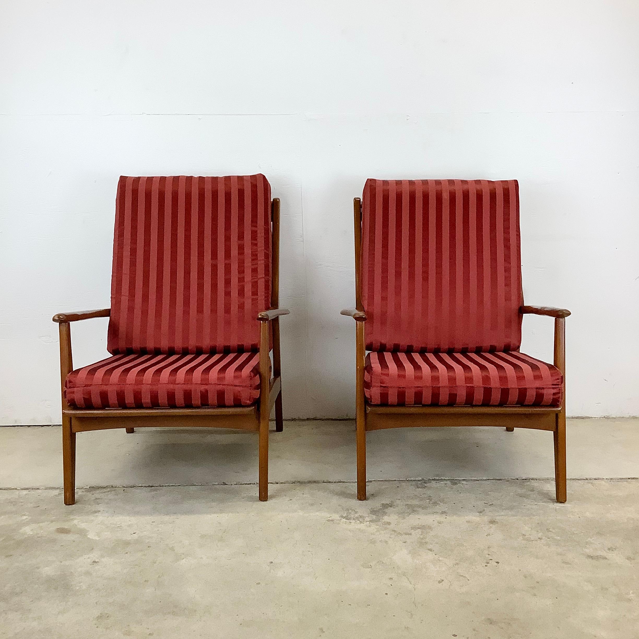 Introducing this pair of mid-century high-back walnut frame lounge chairs, an epitome of mcm elegance and comfort. These chairs, with their sleek walnut frames, feature removable seat and back cushions upholstered in a rich maroon red fabric,
