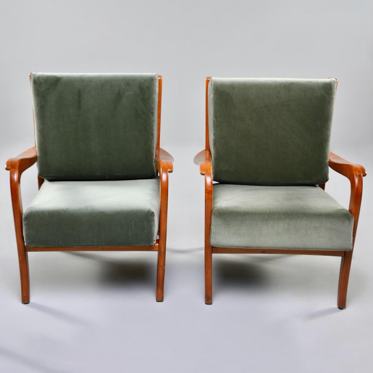 Pair of circa 1950s Italian armchairs feature curvy cherry frames with slatted backs and loose, removable cushions newly upholstered in sage green velvet. Unknown maker. Sold and priced as a pair. 

Measures: Arm height: 20” to 22.5” seat height: