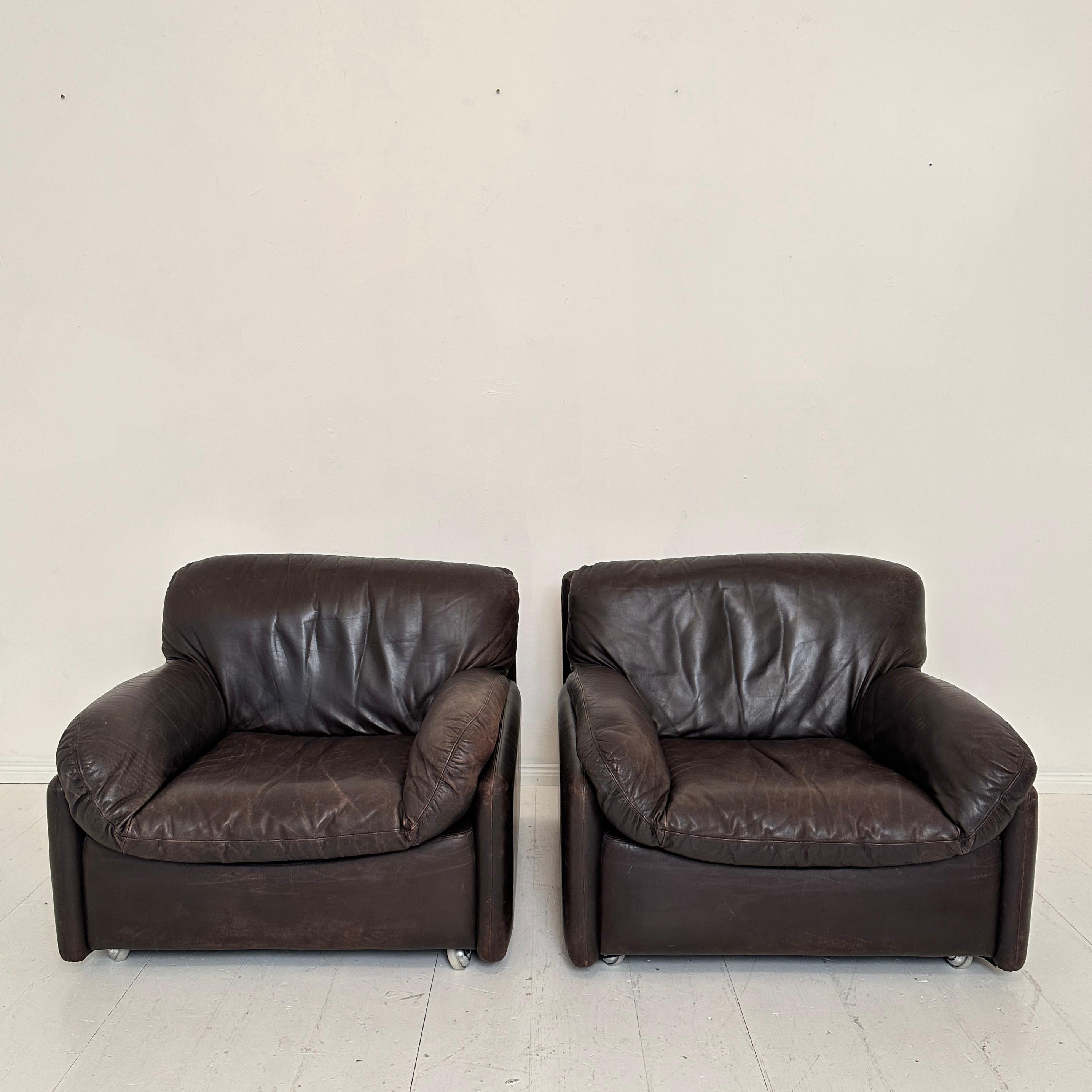 These exquisite Mid Century Italian club chairs, crafted around the 1970s, epitomize the elegance and style of their era. Upholstered in rich brown leather, they showcase a luxurious patina that adds character and warmth to any space. The chairs