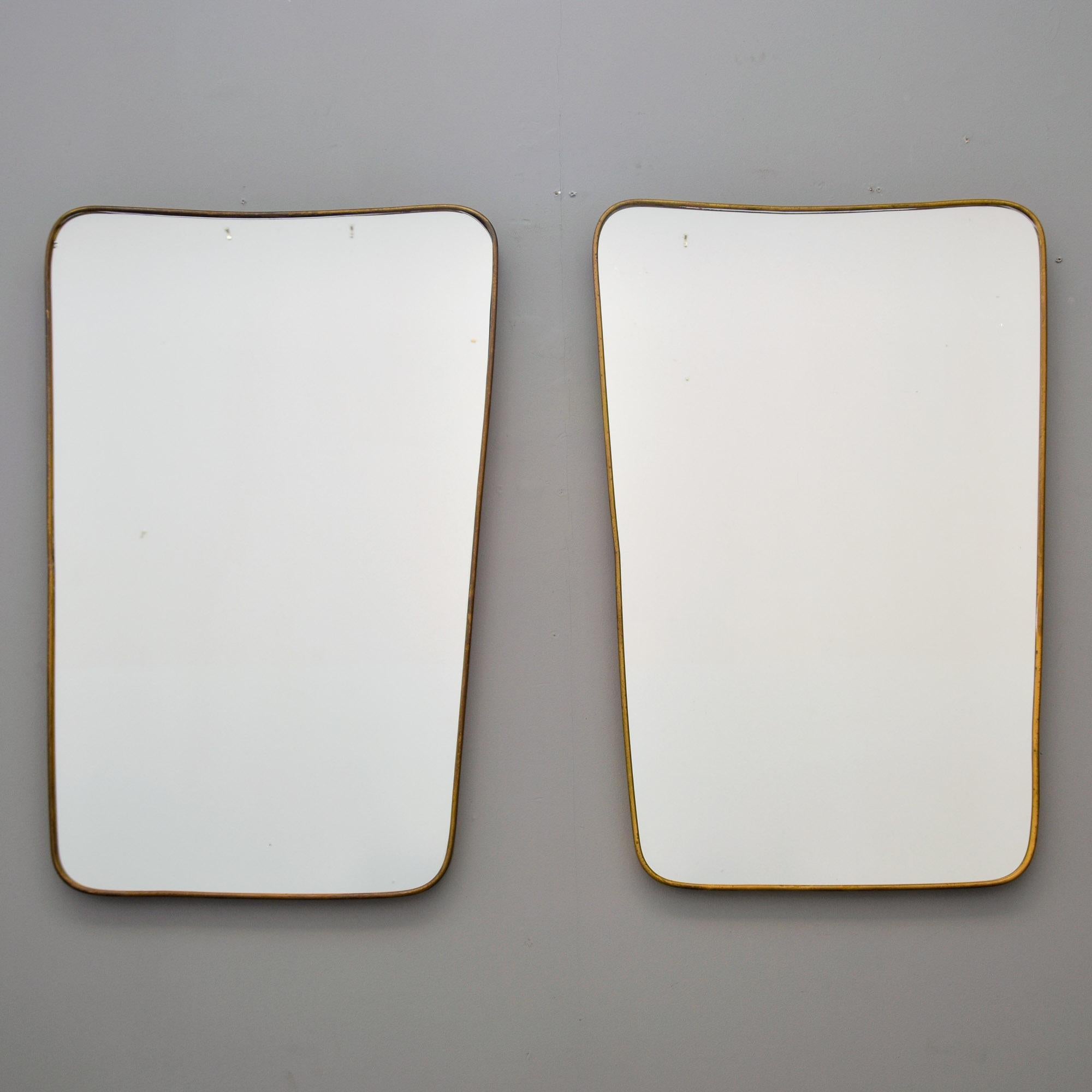 Trovata in Italia, questa coppia di specchi con cornice in ottone in stile Gio Ponti risale alla fine degli anni Cinquanta/inizio anni Sessanta. La forma rettangolare ha angoli arrotondati ed è leggermente più larga nella parte superiore.