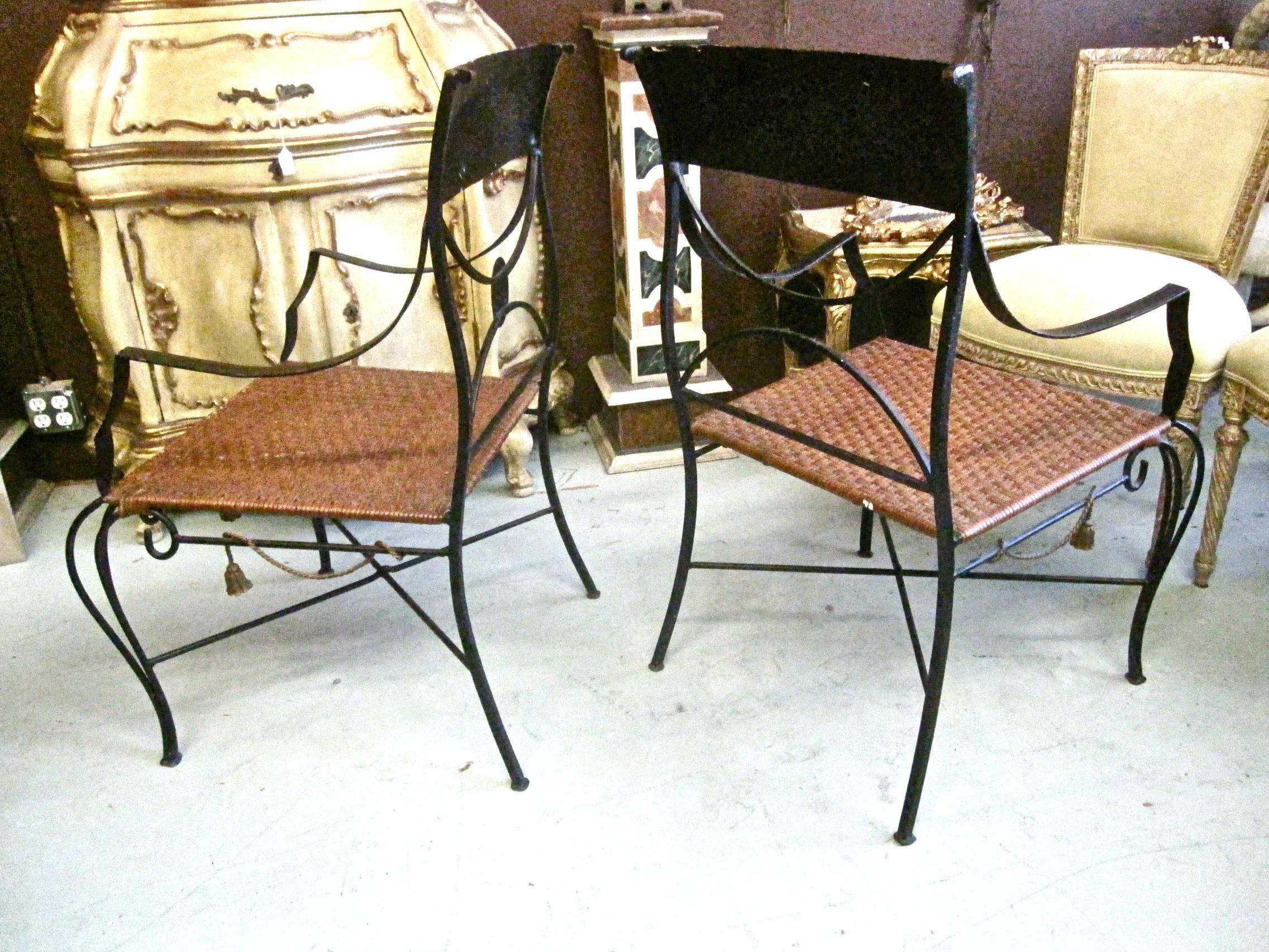 This is a charming pair of circa 1960s Italian painted forged iron and tole arm chairs in a quasi-neoclassical style. The down scrolling arms and modified klismos form echo early 19th century French iron pieces, but then you come to the funky iron