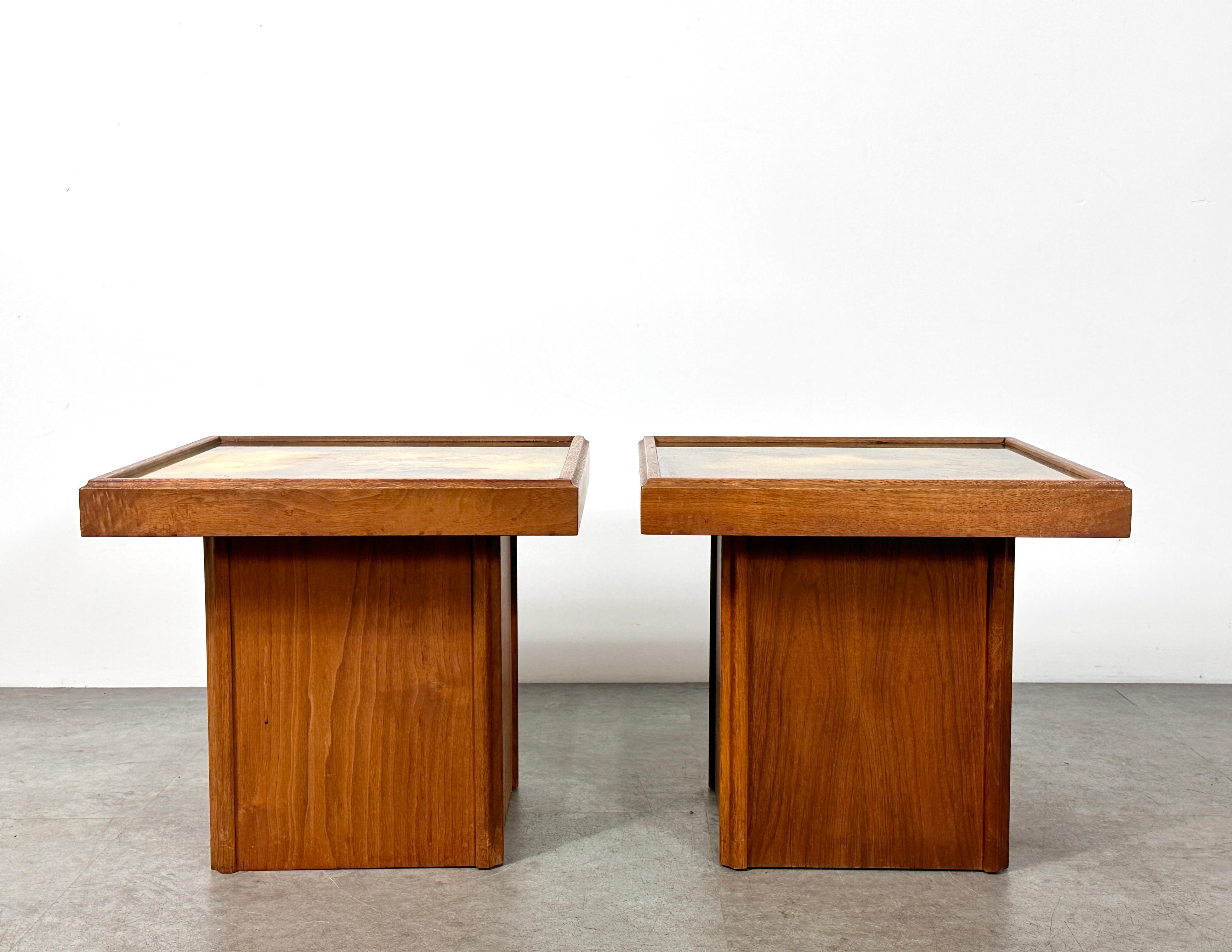 Einzigartiges Paar Beistelltische, entworfen von John Keal für Brown Saltman, ca. 1950er Jahre
Quadratische Sockel aus Nussbaumholz mit dekorativen, hinterlackierten Glasflächen in gesprenkelten Goldtönen
Beide Tabellen behalten ihr ursprüngliches