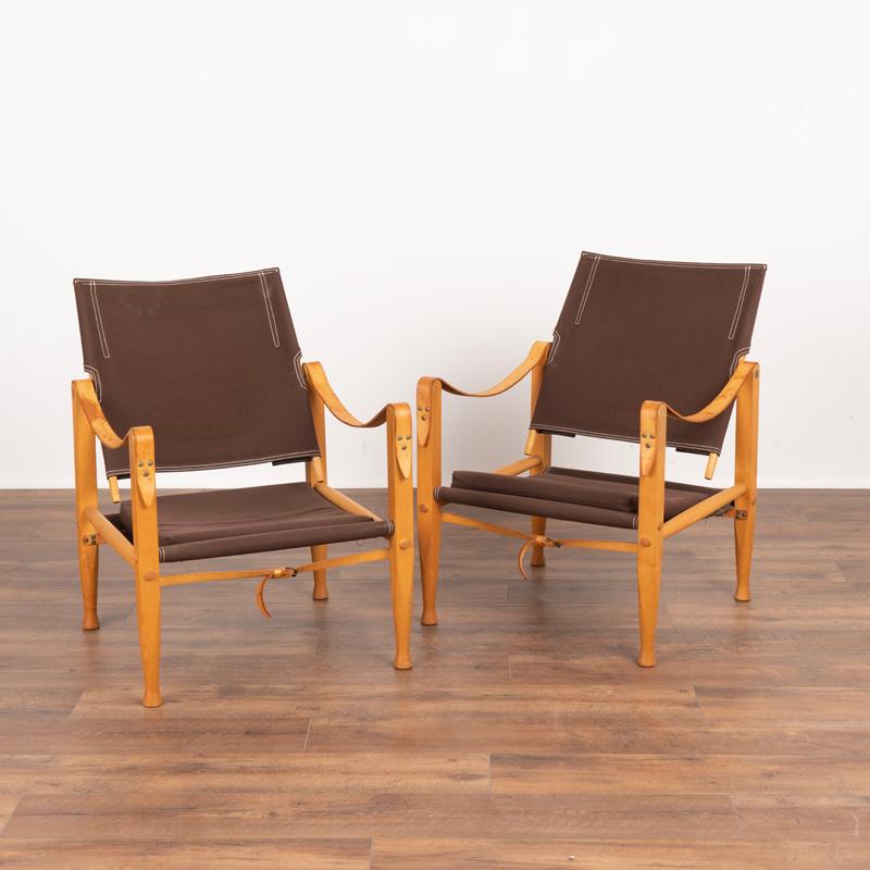 Merveilleuse paire de chaises safari Kaare Klint conçues en 1933 et produites dans les années 1960 par Rud Rasmussen. Ces chaises présentent des lignes bien conçues en combinaison avec des joints en bois soigneusement travaillés. La toile marron à